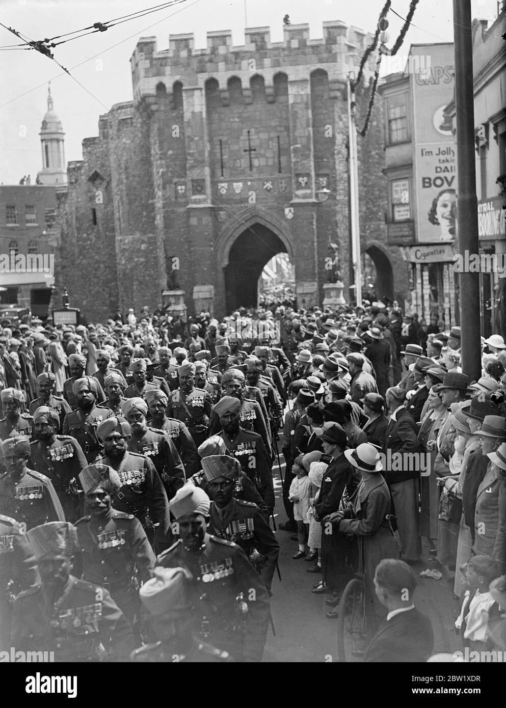Indian Coronation contingent leaves Hampton Court for home. Members of Indian and Burma Coronation Contingent left their encampment at Hampton Court and entrained for Southampton where they will embark on Neuralia for home. There are 600 men in the contingent. Photo shows: the Indian troops marching through the historic Bargate at Southampton. 25 May 1937 Stock Photo