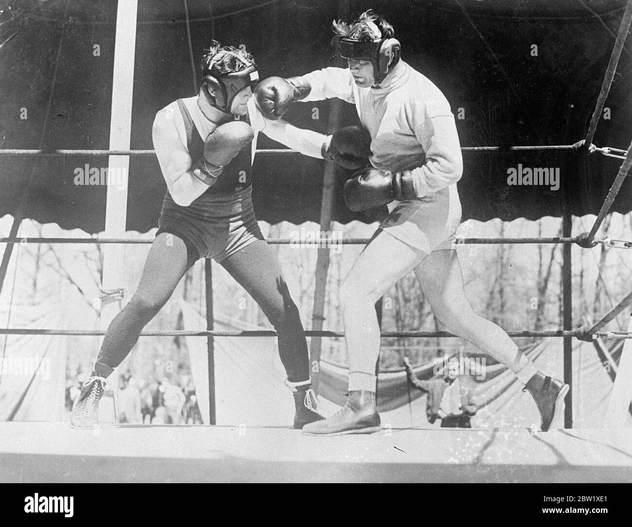 World's champion trains to defend title. James J. Braddock, world's heavyweight boxing champion, is training at Grand Beach, Michigan, to defend his title against Joe Lewis in Chicago next month. Photo shows: James J. Braddock (right) sparring with Jack McCarthy at his Michigan camp. 26 May 1937 [?] Stock Photo