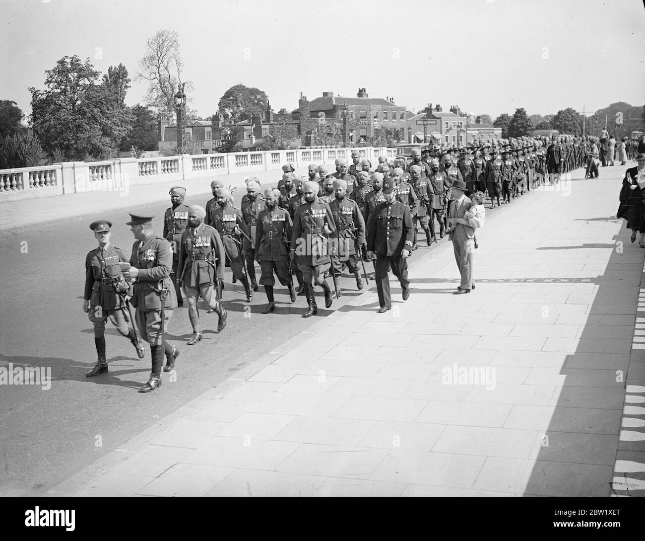 Indian Coronation contingent leaves Hampton Court for home. Members of Indian and Burma Coronation Contingent left their encampment at Hampton Court and entrained for Southampton where they will embark on Neuralia for home. There are 600 men in the contingent. Photo shows: the contingent marching over Hampton Court Bridge. 25 May 1937 Stock Photo