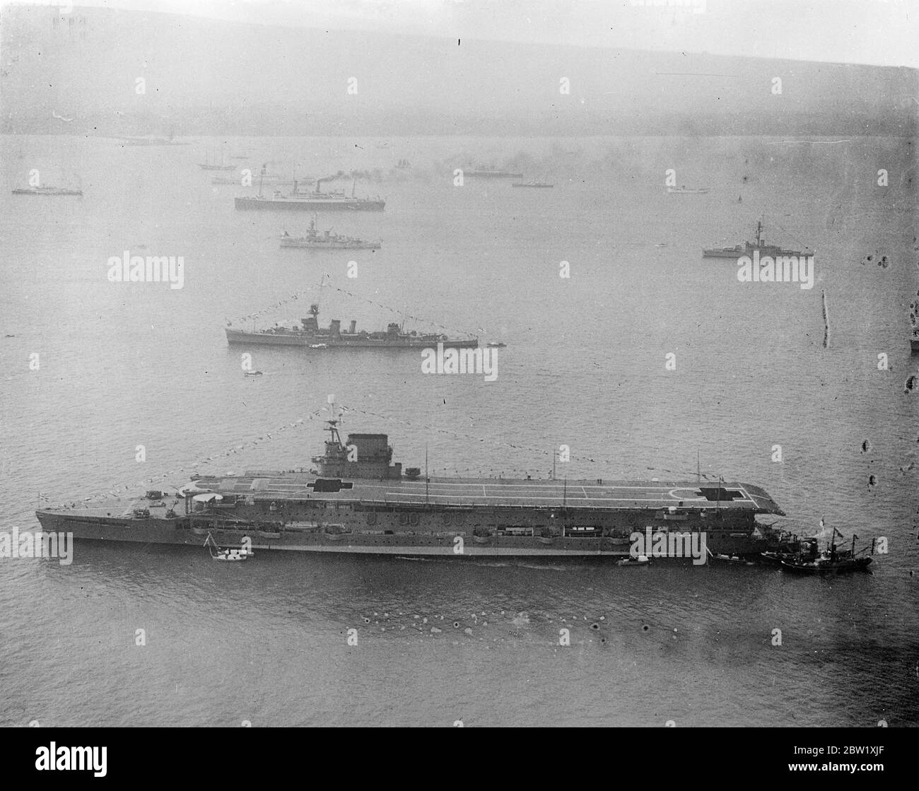 Fleet 'dressed' at Spithead for Kings naval review. An aerial view of warships gaily 'dressed' at Spithead for the Coronation review of the fleet by the King and Queen. In foreground is HMS Glorious with both her deck lifts down. 20 May 1937 Stock Photo