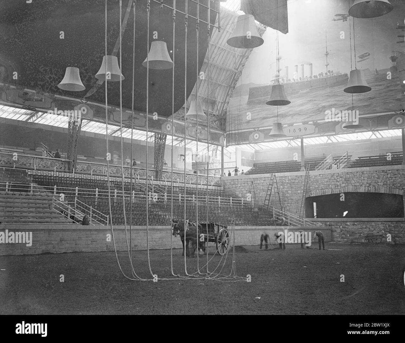 Preparing Olympia for the Royal tournament. Men preparing the surface of the arena at Olympia, London, in readiness for the Royal tournament opening Thursday. 23 May 1937 Stock Photo
