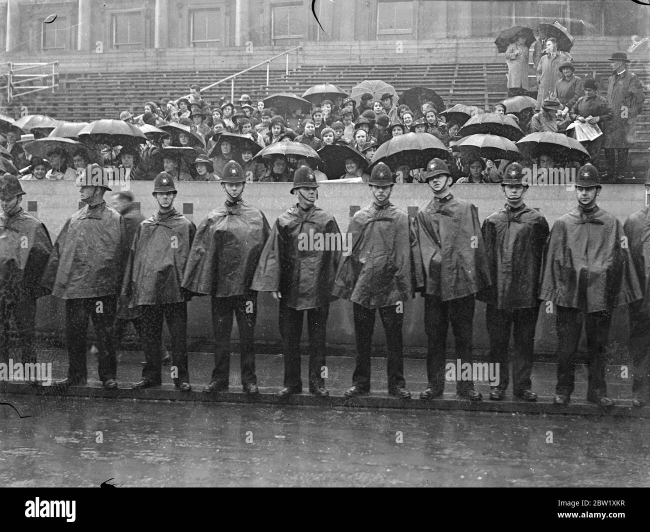 Police in the rain perform crowd control Stock Photo