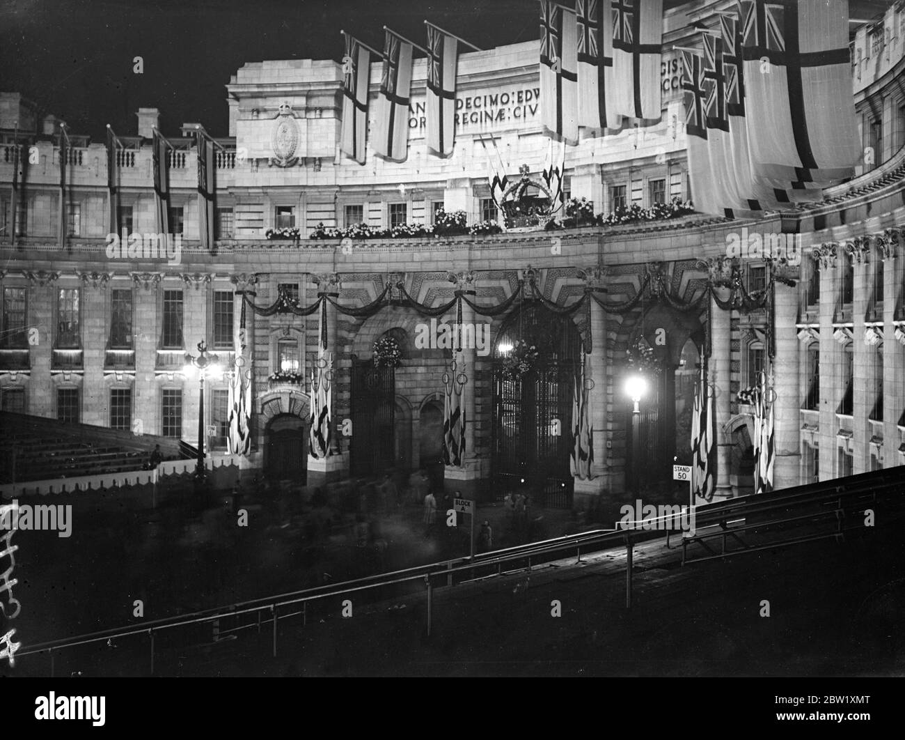 London floodlit for Coronation season - crowds gather for spectacle. Great crowds gather on the first official night of the Coronation floodlighting. All London's most important buildings are illuminated and the entire area is closed to traffic. Photo shows: the Admiralty Arch under floodlights. 13 May 1937 Stock Photo