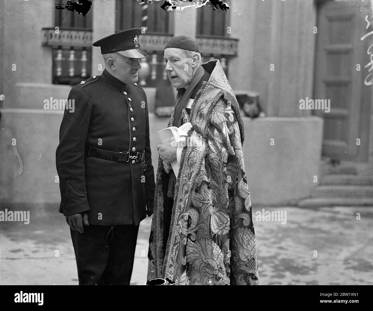 Bishop of Norwich at final Coronation rehearsal. Photo shows: the Bishop of Norwich, in his robes, talking to a police inspector as he left Westminster Abbey after attending the final rehearsal of the Coronation ceremony. 10 May 1937 Stock Photo