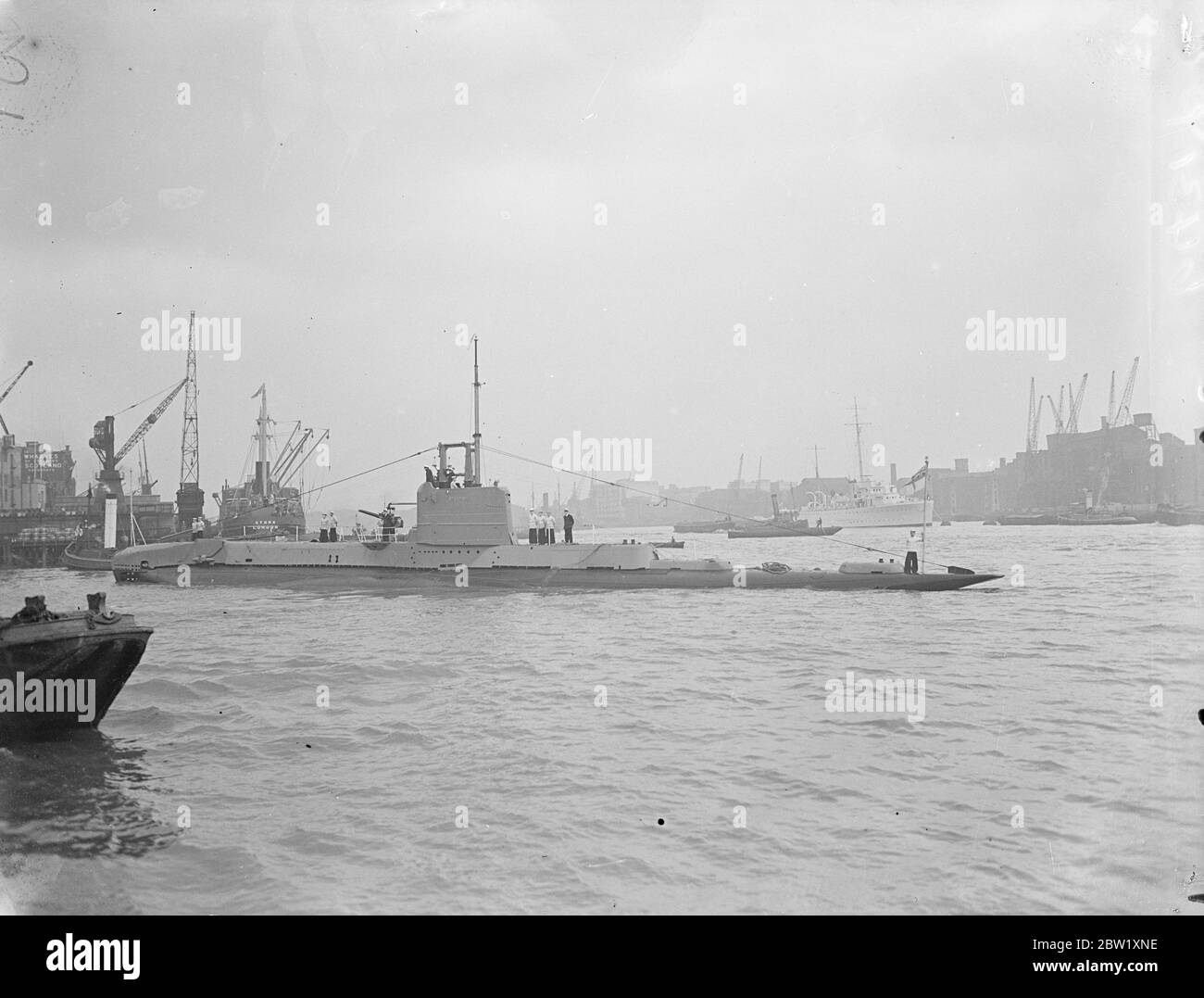 London sees the Navy. Submarines in dock near Tower Bridge. Submarines of the Home Fleet which have been stationed in the Pool of London for the Coronation, were opened for inspection by visitors only a few hours after their arrival. Photo shows: HMS Starfish (19S) Group one British S class submarine in St Katharine's Dock, London. 7 May 1937 Stock Photo