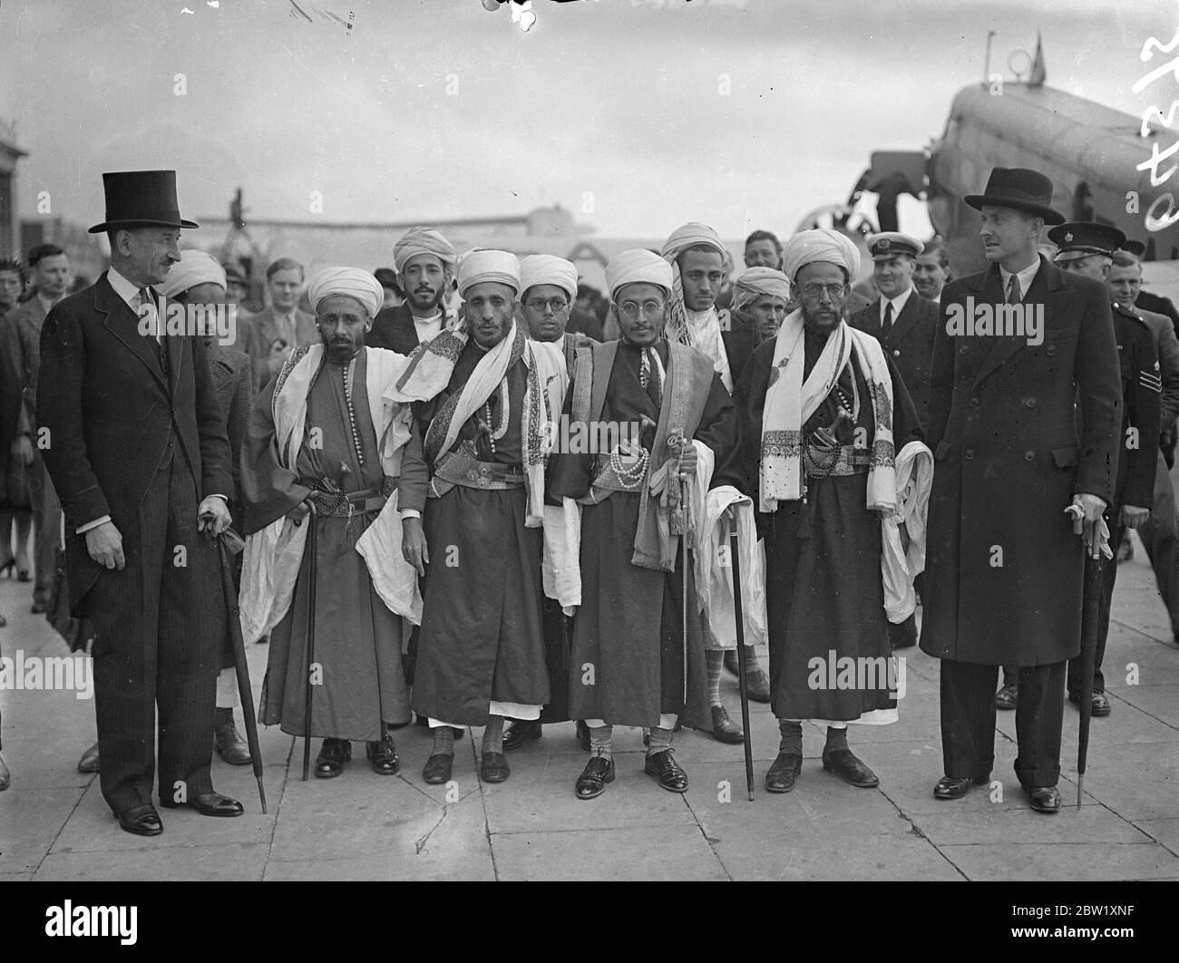 Emir of Yemen flies to England for Coronation. To represent his father, the King of Yemen, the Emir, Seif-al-Islam Hussein arrived at Croydon by special plane. He was met by Colonel Kenny of the Foreign Office. Photo shows: the Emir of Yemen with Colonel Kenny and his suite on arrival at Croydon. 10 May 1937 Stock Photo