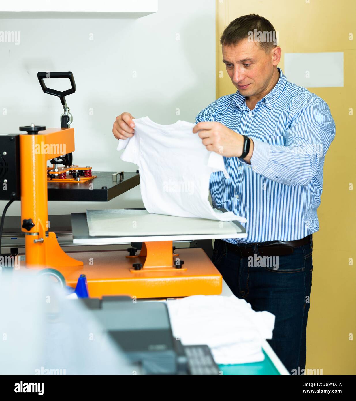 Man printing t-shirt in a workshop Stock Photo