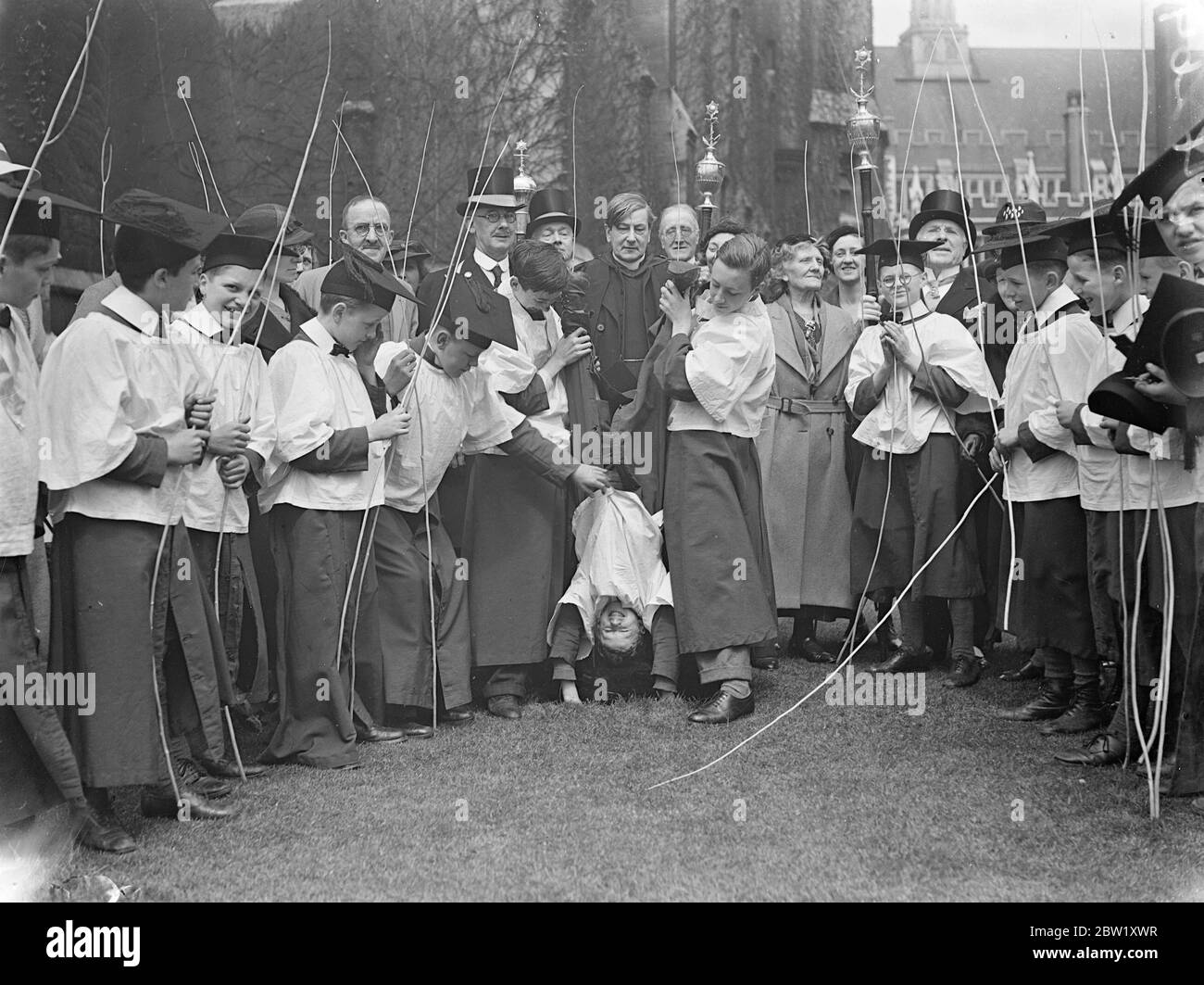 Choirboy sees London for a new angle. Beating Bounds at Temple. Armed with willow wands, choirboys carry out the Rogation tied ceremony of Beating the Bounds of St Clement Danes Church, Strand, London today (Ascension Day). Photo shows, choirboy sees London from an unusual angle during the ceremony in the temple. 6 May 1937 Stock Photo