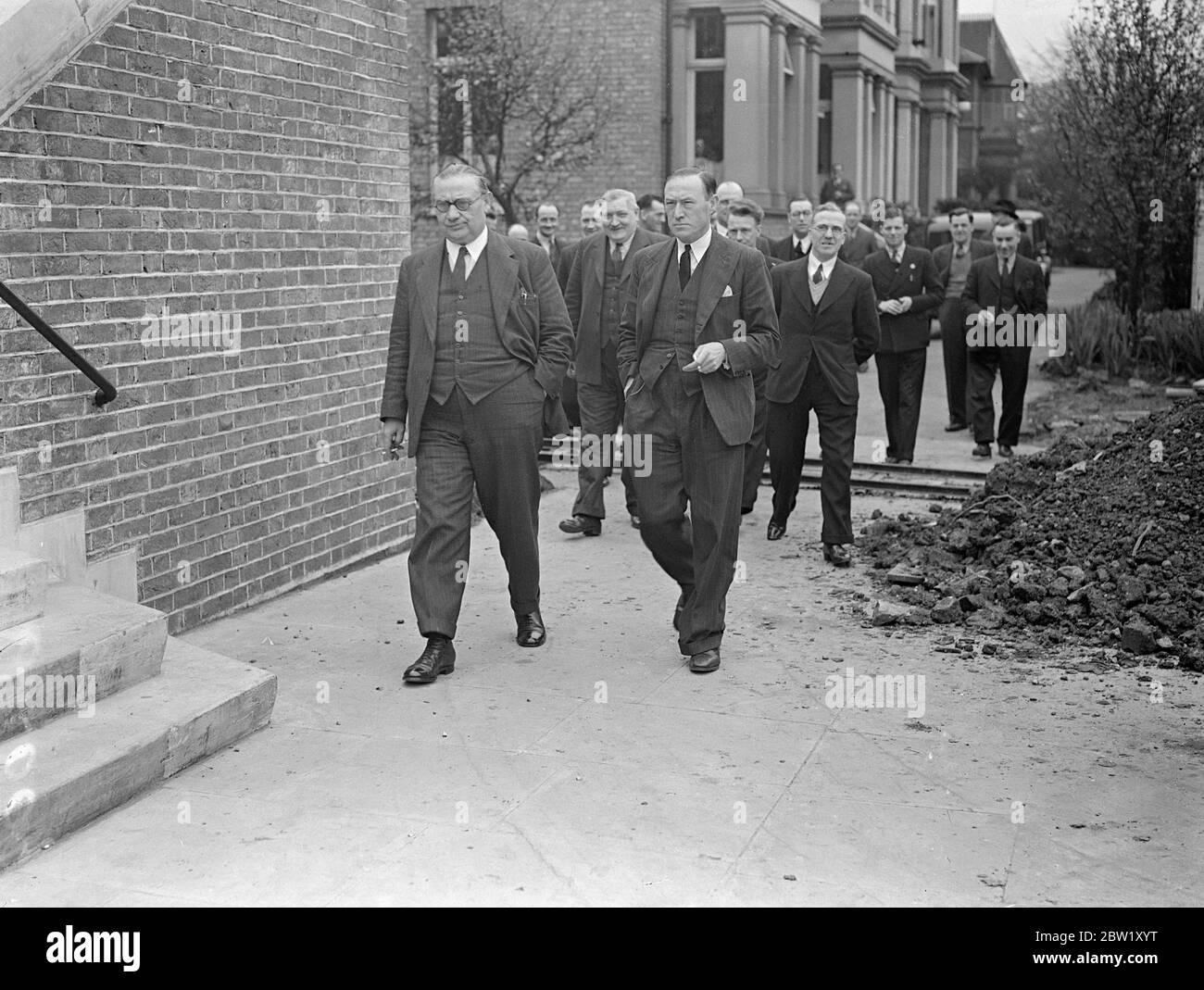 Bus delegates meet in London to consider strike action . A meeting of bus delegates of the transport And General Workers Union was held at the Woodberry Hall, Green Lane, Stoke Newington, when it was expected that final endorsement of strike action would be given following the complete failure of the negotiations which have been proceeding all the week. Photo shows, delegates leaving after the meeting. Ernest Bevan (left) is on left with glasses. 30 April 1937 Stock Photo
