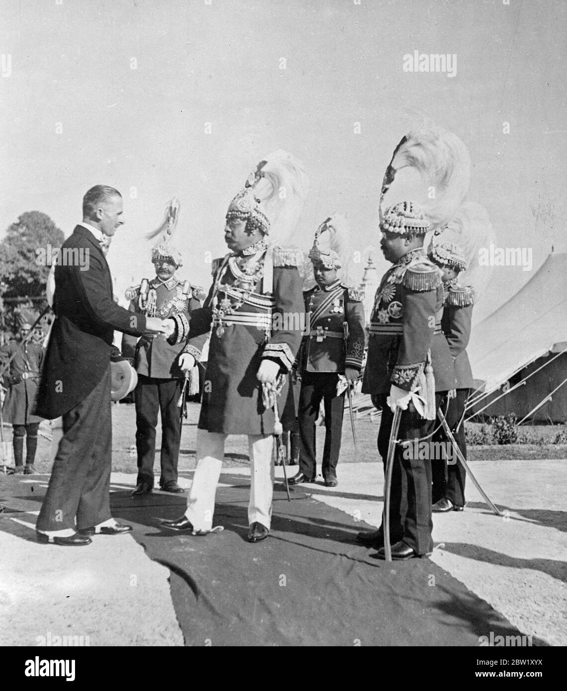 Exclusive pictures of the silver jubilee of the King of Nepal. These exclusive pictures illustrate the celebrations which took place in connection with the silver jubilee of the Trubhubana Bis Vikram Sah, 31-year-old King of Nepal, who came to the throne in 1911. The whole capital put on Gala attire and tens of thousands of subjects watched the parade of jewelled elephants and the entire army in review. These pictures were taken by special invitation in the capital, Kathmandu. Photo shows, the Prime Minister, Sir Joodha Shumshere Jung Bahadur Rana, greeted by Mr R Kilburn, only European in the Stock Photo