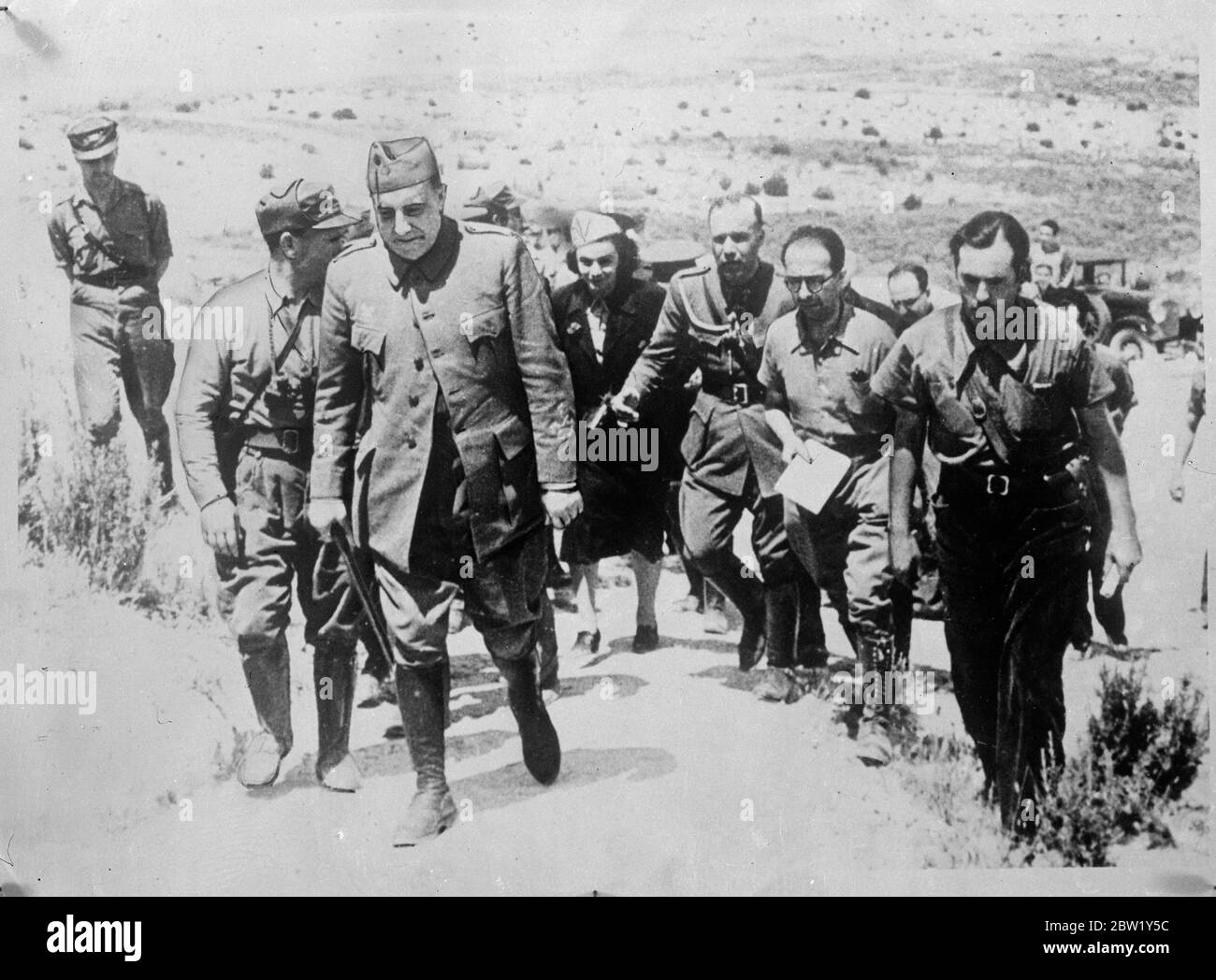 Loyalist commandos visits the Aragon front. General Pozas, the Spanish Government commander in the East, made a tour of the front line in Aragon, where the loyalist forces have been reported to be making successful attacks on the rebels. Photo shows, General Pozas (foreground) , touring the Aragon front with members of his staff. A woman can be seen in the party. 11 June 1937 Stock Photo