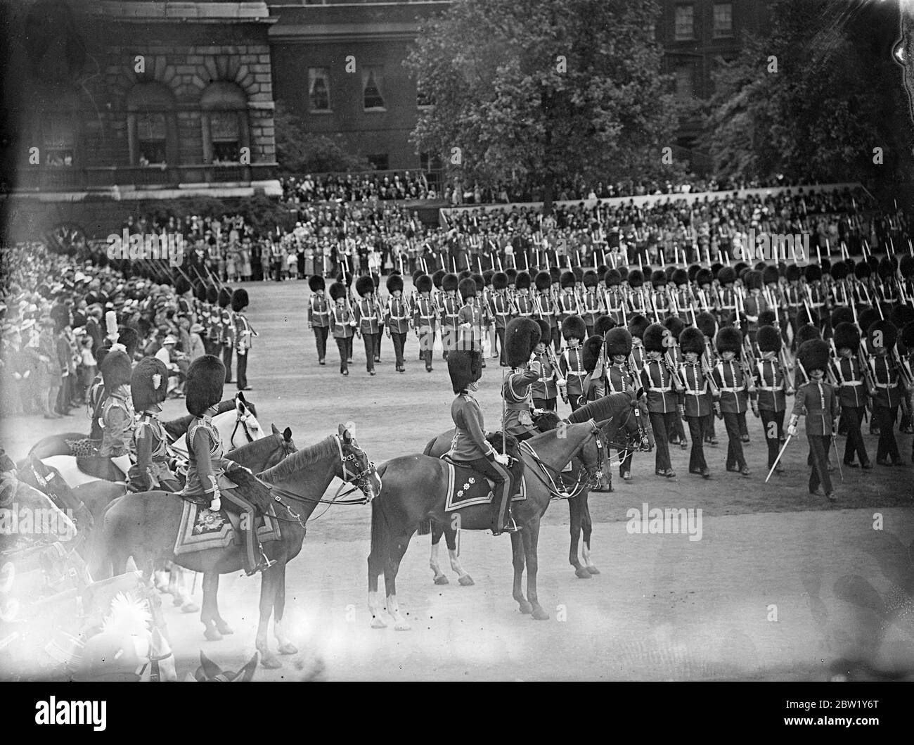 King at Trooping the Colour ceremony. For the first time since his succession the King rode in procession from Buckingham Palace to attend the ceremony of Trooping the Colour on the Horse Guards Parade. The King was accompanied by the Duke of Gloucester and Kent and Prince Arthur of Connaught. The Queen and other members of the Royal Family watched the ceremony. The colour of the first Battalion Coldstream Guards was trooped. Photo shows: the march past the King. 9 June 1937 Stock Photo