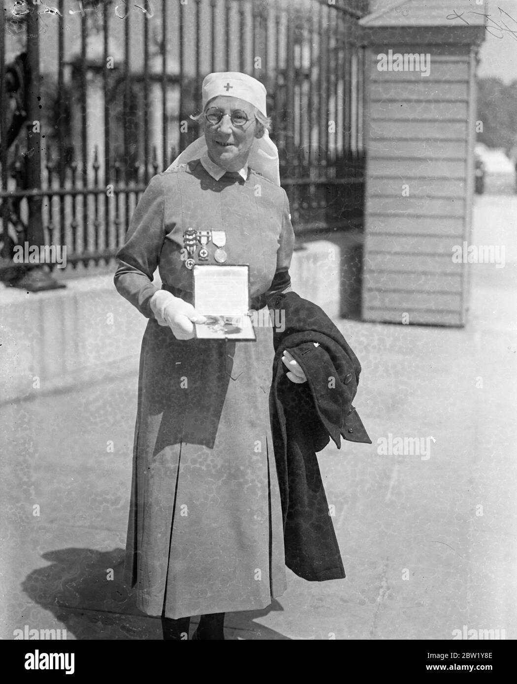 King held an investiture at Buckingham Palace. Photo shows, Mrs E A Beaumont of the Red Cross after receiving her MBE. 11 June 1937 Stock Photo