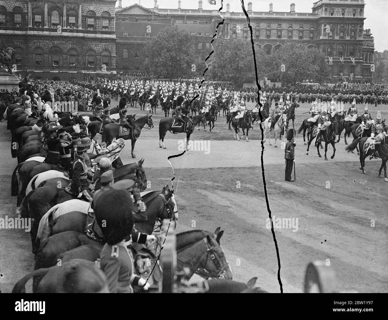 Cavalry in March past at Trooping the Colour. For the first time since his succession the King rode in procession from Buckingham Palace to attend the ceremony of Trooping the Colour on the Horse Guards Parade. The King was accompanied by the Duke of Gloucester and Kent and Prince Arthur of Connaught. The Queen and other members of the Royal Family watched the ceremony. The colour of the first Battalion Coldstream Guards was trooped. Photo shows: cavalry marching past the King. 9 June 1937 Stock Photo