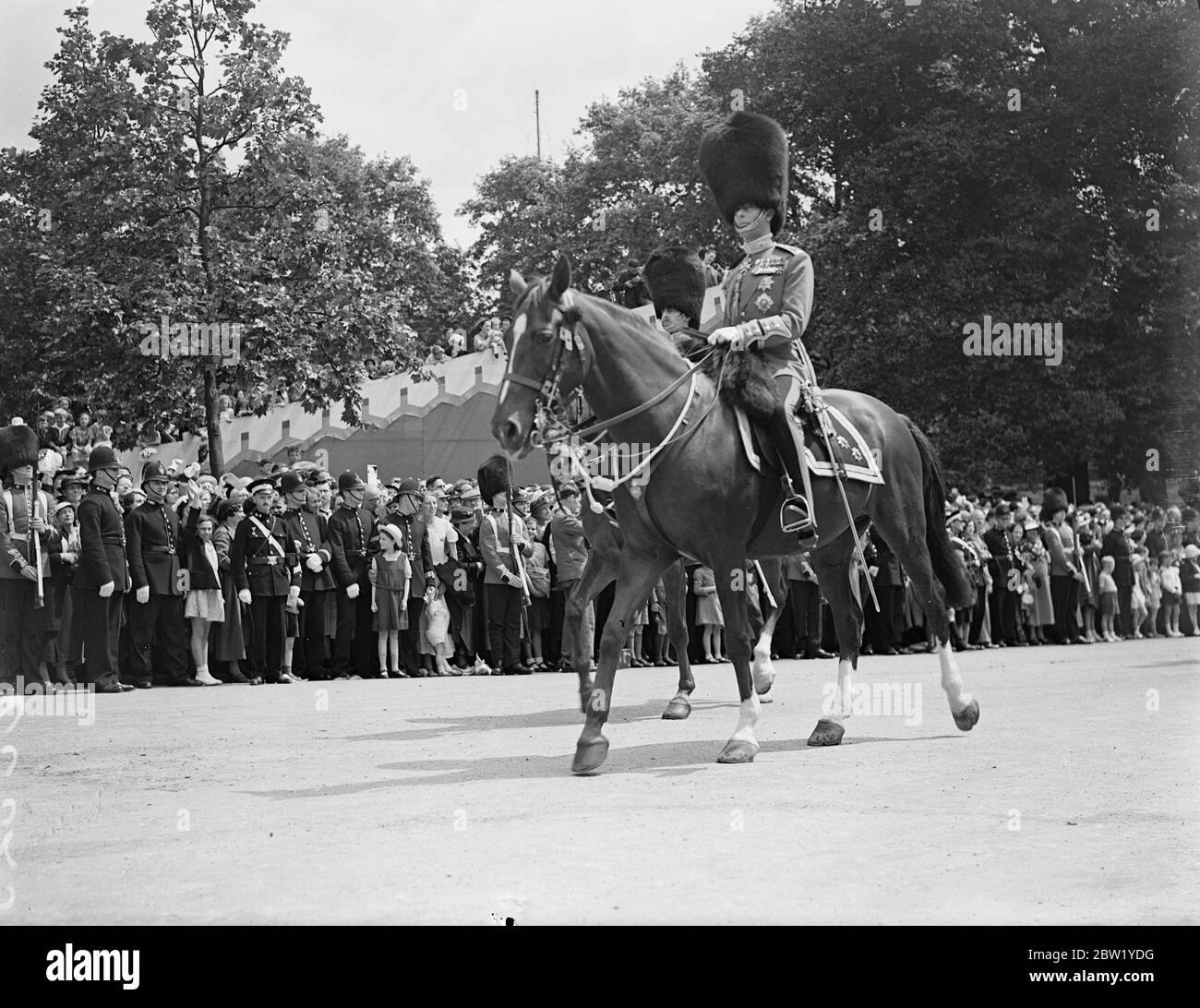 King rides in procession to Horse Guards for Trooping the Colour. For the first time since his succession the King rode in procession from Buckingham Palace to attend the ceremony of Trooping the Colour on the Horse Guards Parade. The King was accompanied by the Duke of Gloucester and Kent and Prince Arthur of Connaught. Photo shows: the King as he led the Guards back to Buckingham Palace. 9 June 1937 Stock Photo