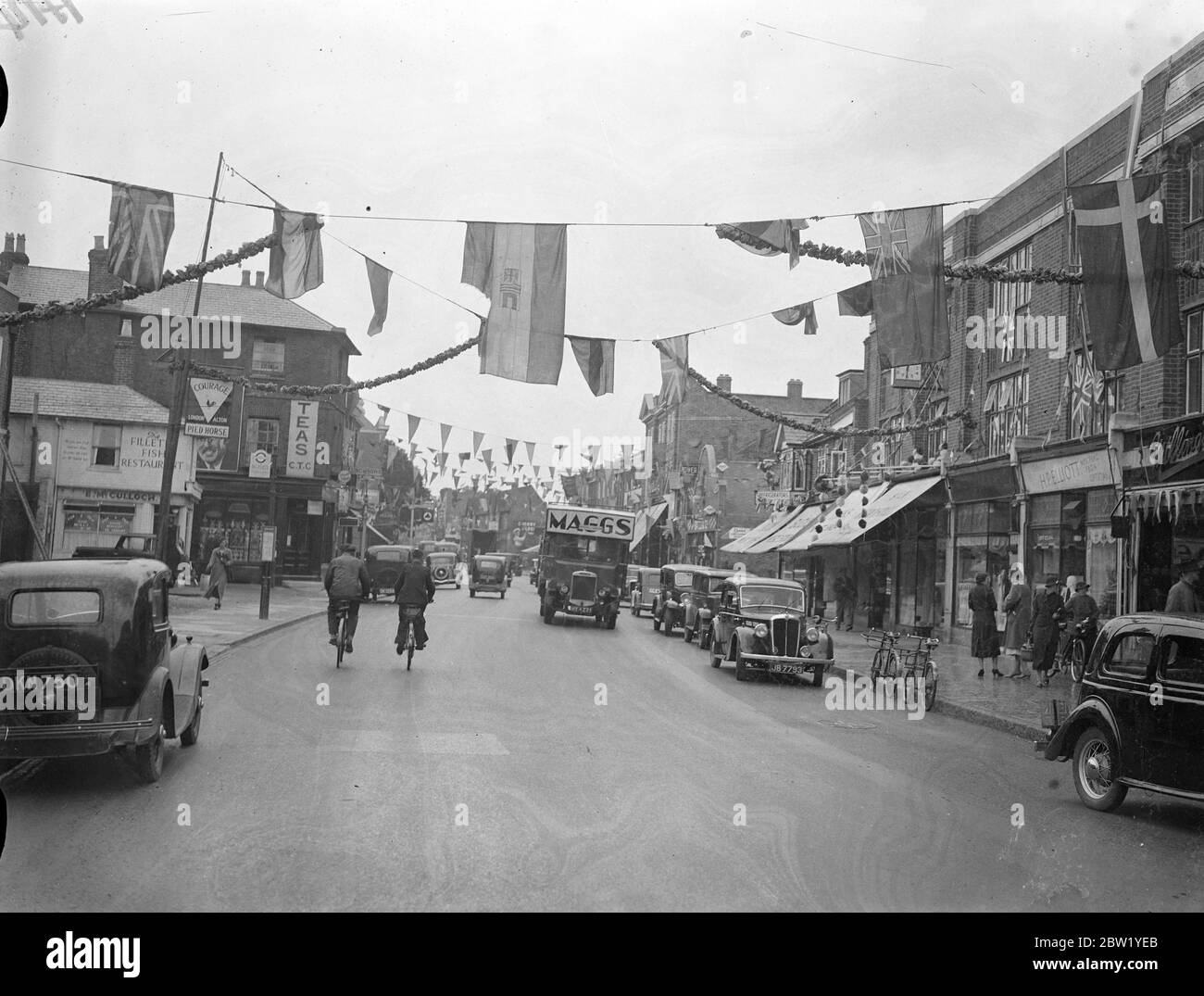 Slough prepares to welcome the King and Queen. Slough (Buckinghamshire), through which the King and Queen will drive on their State entry into Windsor, is being decorated in preparation for the Royal visit next Saturday, 12 June. Photo shows, Slough high Street decorated to welcome the King and Queen. 9 June 1937 Stock Photo