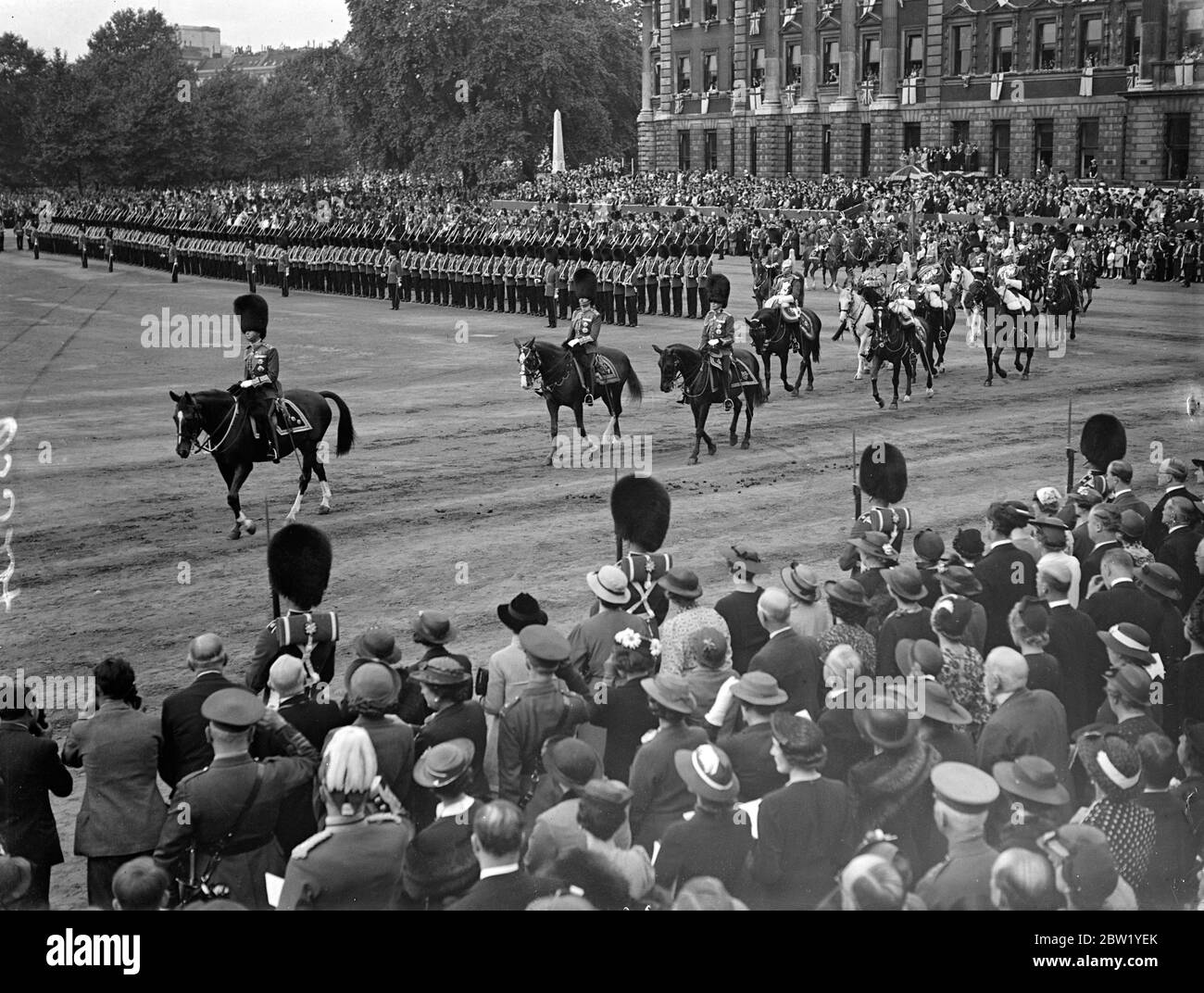 King rides in procession to Horse Guards for Trooping the Colour. For the first time since his succession the King rode in procession from Buckingham Palace to attend the ceremony of Trooping the Colour on the Horse Guards Parade. The King was accompanied by the Duke of Gloucester and Kent and Prince Arthur of Connaught. The Queen and other members of the Royal Family watched the ceremony. Photo shows: the King arriving on the parade ground. 9 June 1937 Stock Photo