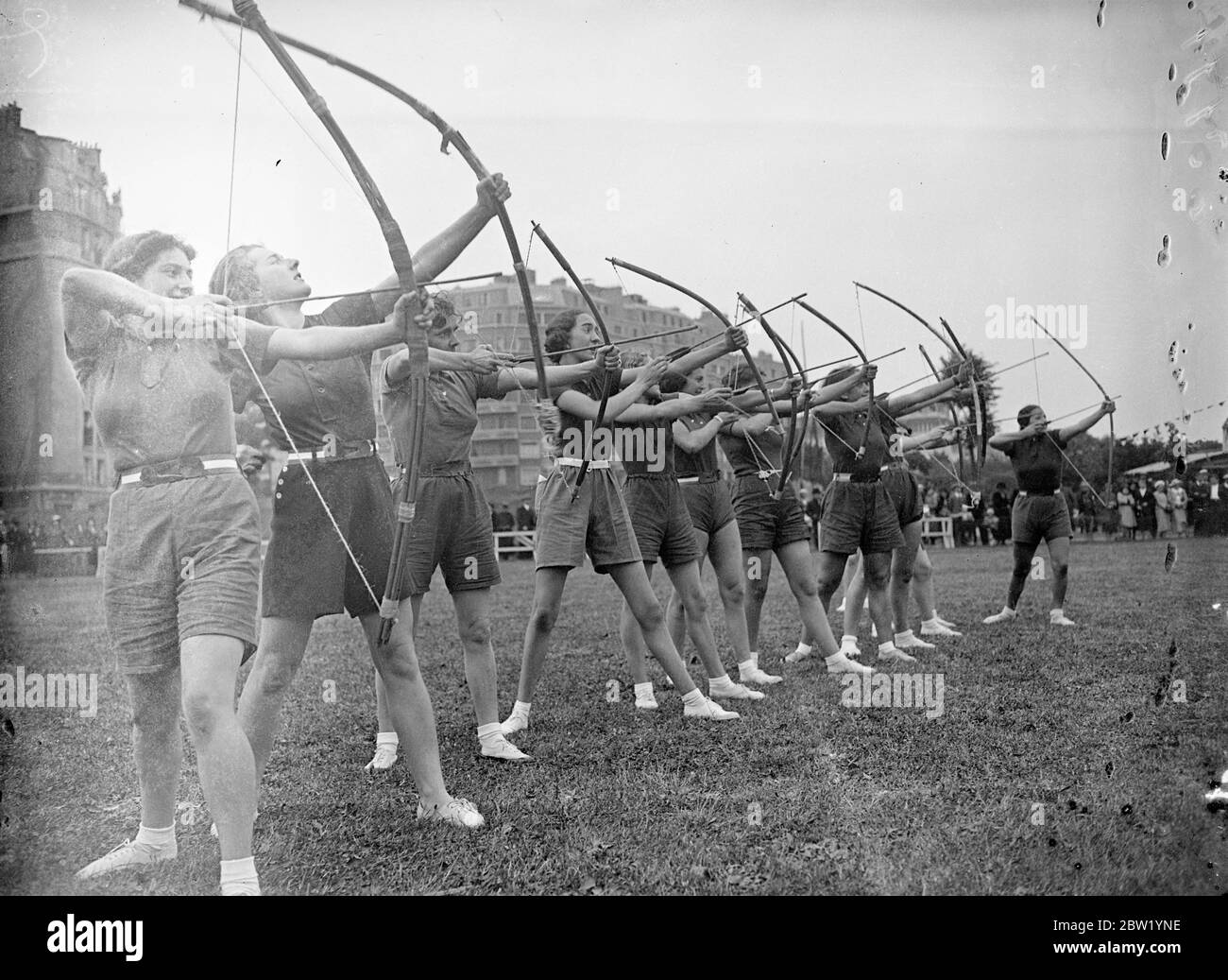 French girl shoots straight with the bow. Nearly 1000 young girl athletes met in their 10th competition at the Stade Elizabeth near the Port d'Orleans in Paris. Photo shows, girl competitors in the archery contest taking aim. 21 June 1937 Stock Photo