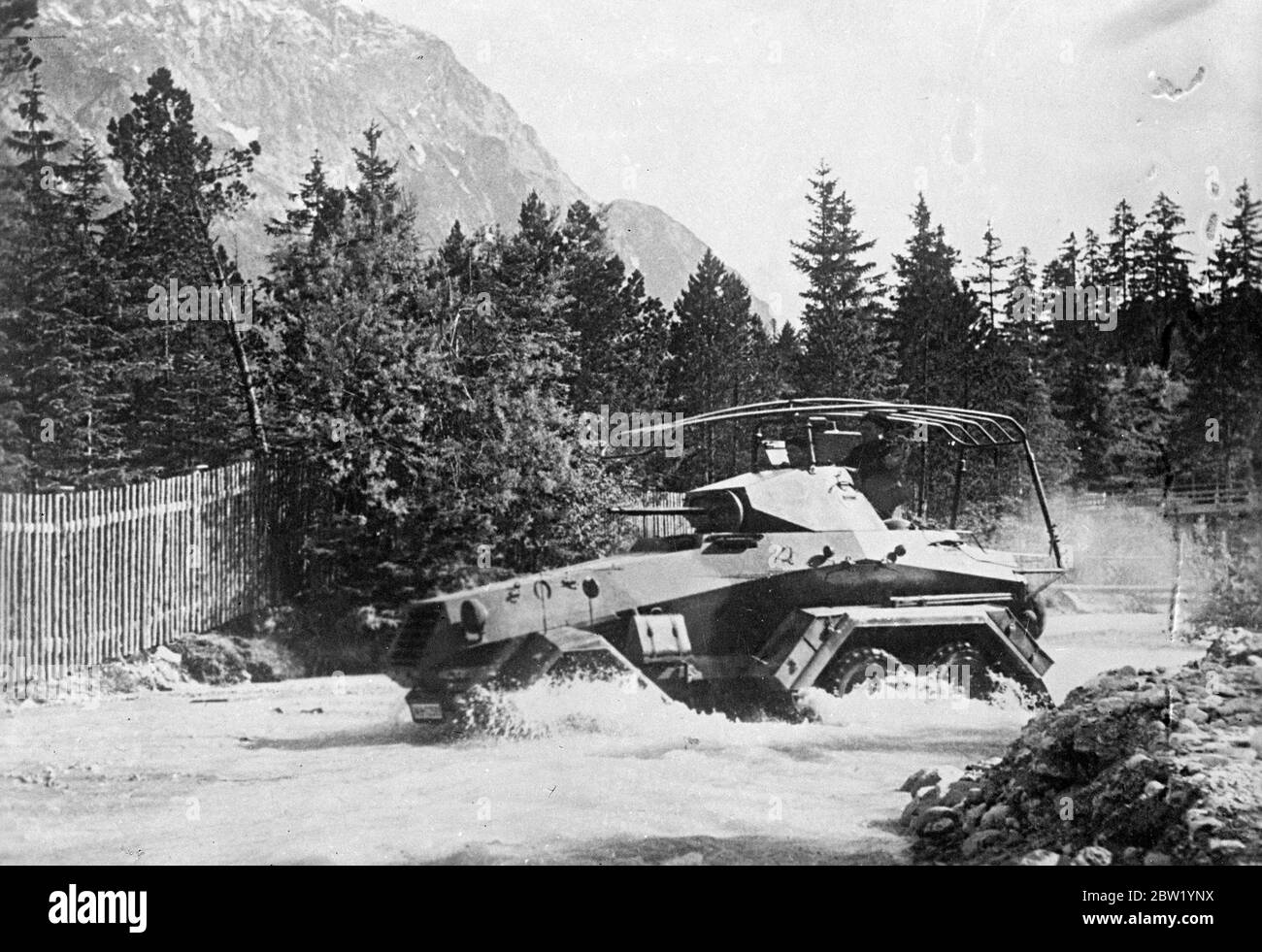 Germany's mechanised army at exercise in the mountains. Armoured units of the German army carrying out exercises in the mountains near Mittenwald. Photo shows, one of the latest armoured cars speeding through a stream. 21 June 1937 Stock Photo