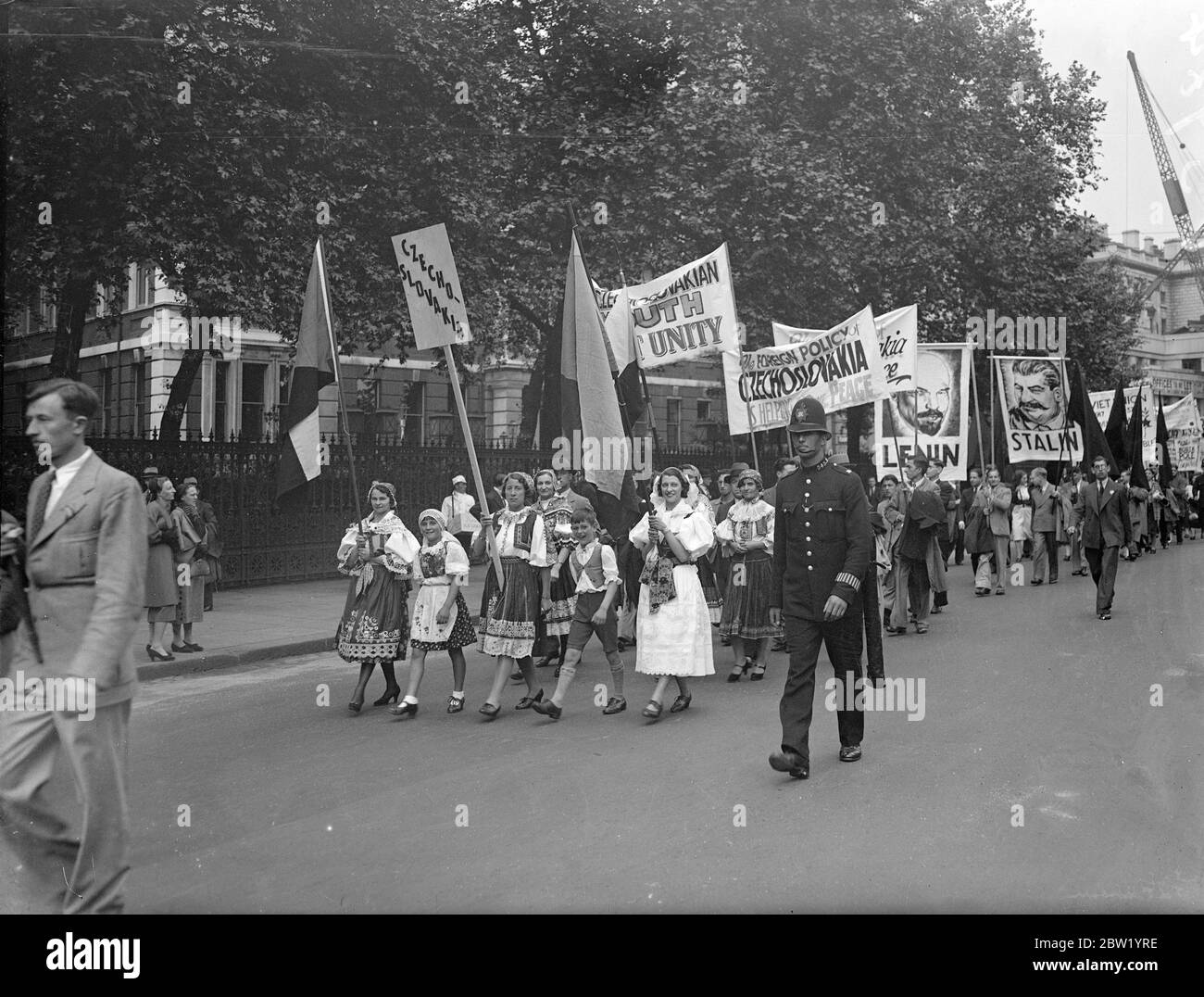 2000 rally in pageant of pace. March to Hyde Park. 2000 members of British youth organisation, wearing the national costumes of peaceloving countries. Took part in the gigantic pageant of peace rally to Hyde Park. Photo shows, the procession, led by girls in Czechoslovakian national costume, passing down Victoria embankment to Hyde Park. Photographs of Lenin are carried in the procession. 20 June 1937 Stock Photo