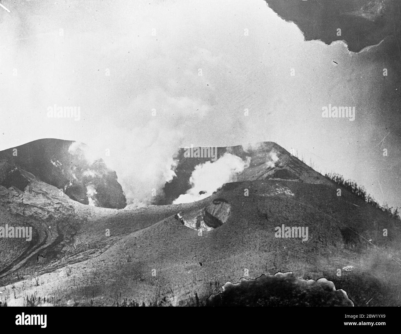Smoke and volcanic mud pouring from the crater on Matupi Island. First pictures of volcano disaster on New Guinea islands. Three volcanoes, 2 on Vulcan Island and one on the Matupi Island, erupted violently showering pumice and mud on the roofs of Rabaul chief town of New Britain Island in New Guinea. A state of emergency was declared. 18 June 1937 Stock Photo