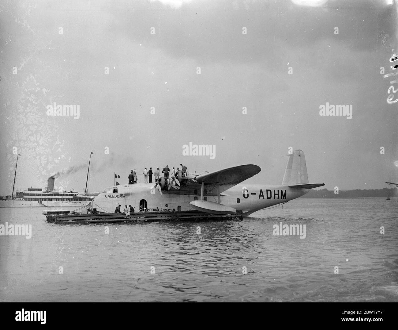 Flying boats 'Caledonia'being prepared for the first commercial Atlantic crossing. The Imperial Airways flying boat 'Caledonia'is being prepared at Hythe for the first experimental commercial transatlantic crossing which she is to make next week (24 June). The 'Caledonia'will be piloted by Capt A S Wilcockson and first officer GH Bowes. Photo shows, mechanics, on top of the Caledonia at Hythe. 19. June 1937 Stock Photo