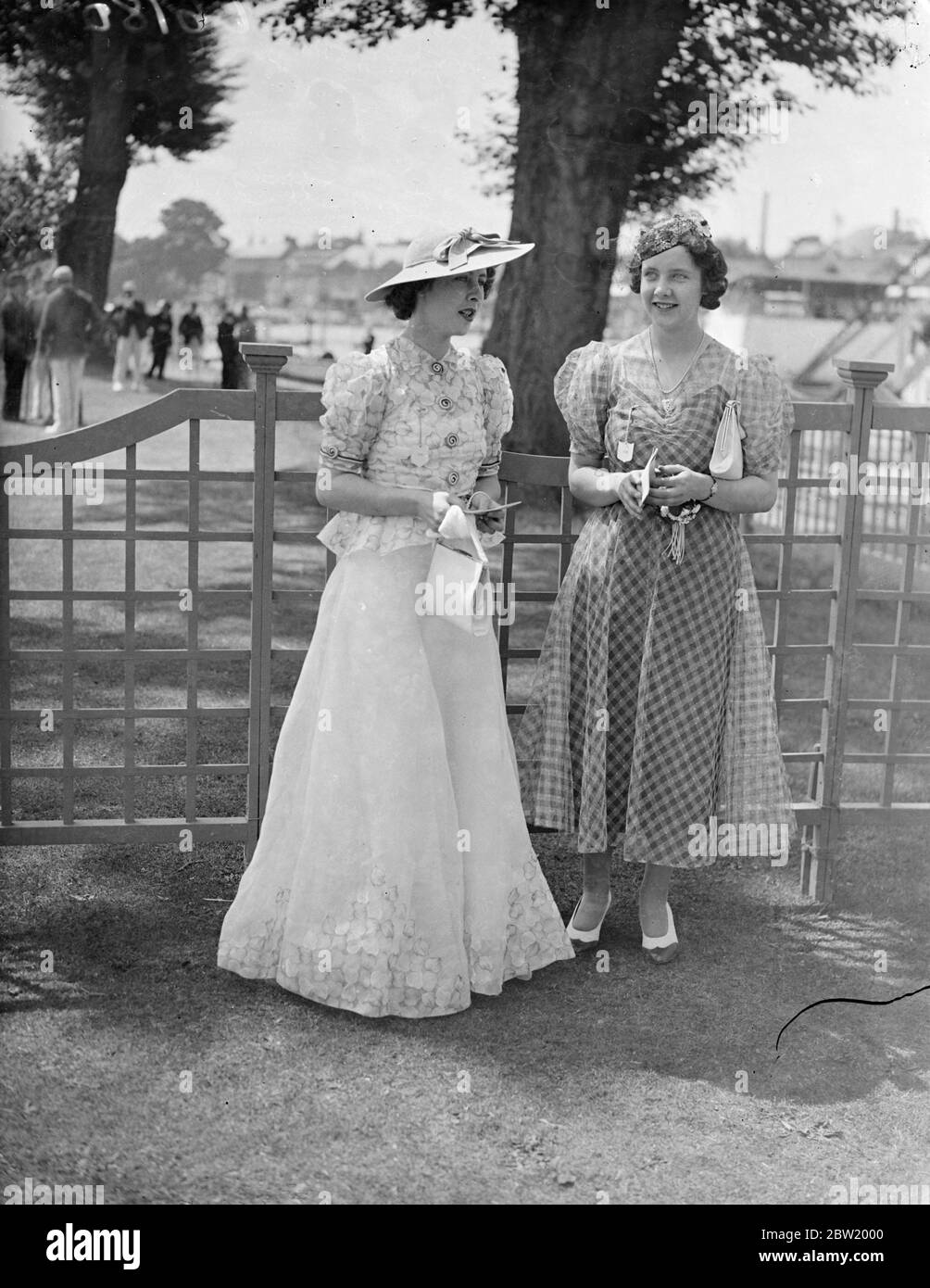 With the heatwave as encouragement, Henley's Royal Regatta vied with Ascot in variety of its fashions. The cool and elegant fashion worn by Miss Frances and Miss Iona McClean when the final day of Henley took place in the blazing July sunshine. 3 July 1937 Stock Photo