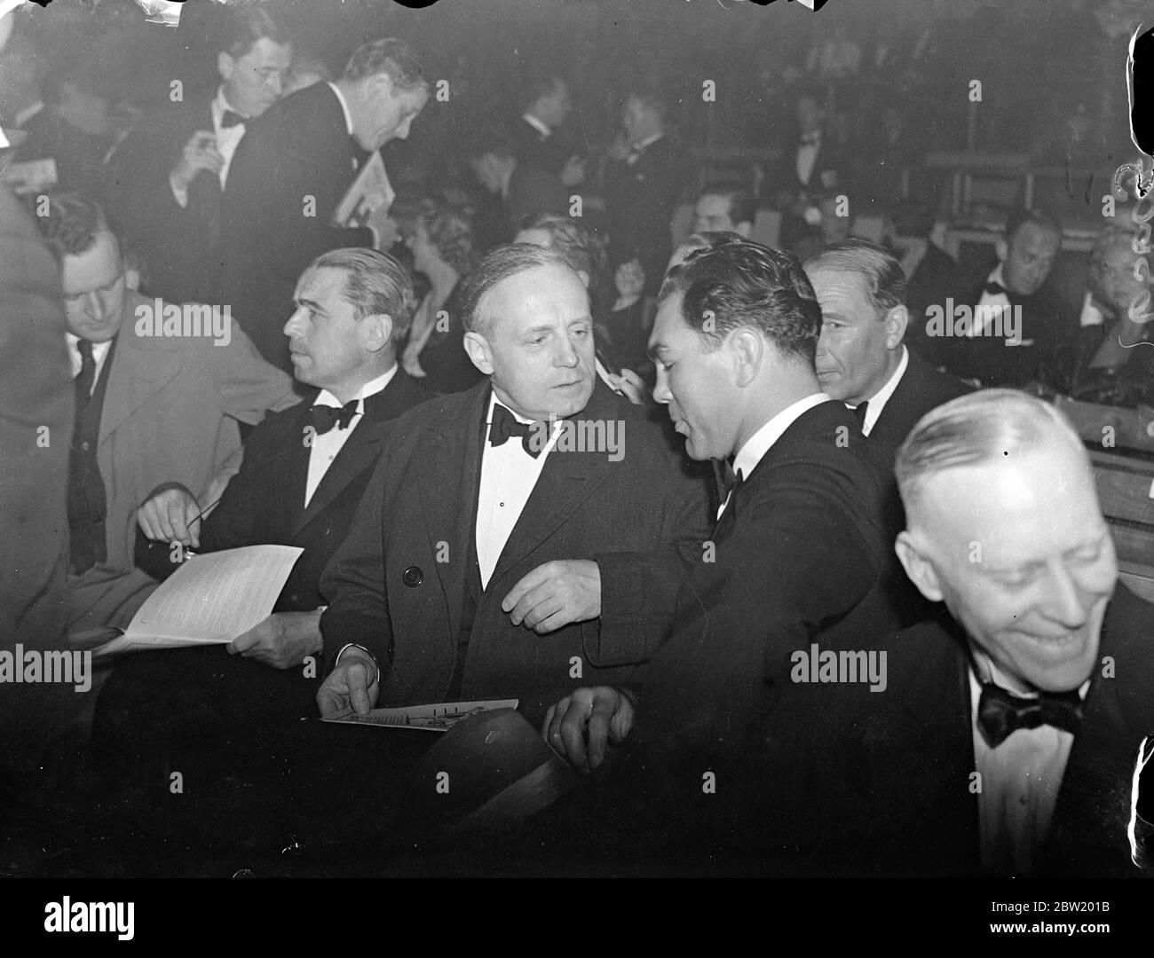 Max Schmeling and German Ambassador, von Ribbentrop, see Farr's knockout victory over Neusel. Max Schmeling, the German heavyweight with whom it is possible the Welshman will be matched, watched Tommy Farr, knock out his countryman, Walter Neusel, in the third round of the match at the Harringay Arena, London. Photo shows: Max Schmeling talking with the German Ambassador, Herr Joachim von Ribbentrop, at the ringside 15 June 1937 Stock Photo