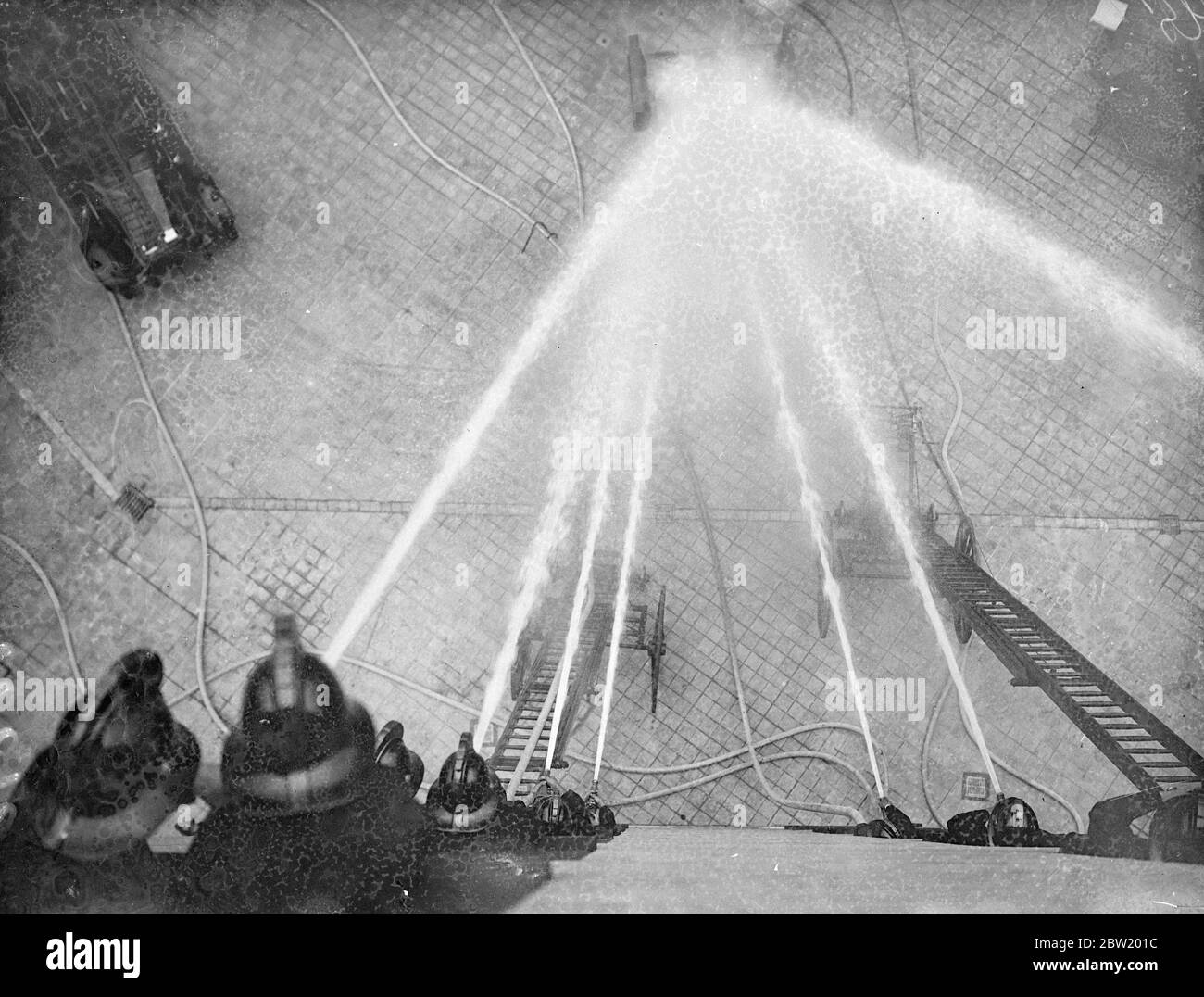 Fireman of the headquarters staff are practising the display they would give when the King and Queen open the new Fire Brigade Headquarters on the Albert Embankment, London today (Wednesday). The new building is of steel construction and is nine storeys high. Fireman directing their hoses on that target during practice. 21 July 1937 Stock Photo