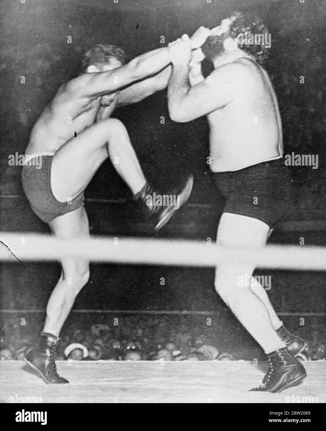 Sandor Szabo to gaining in with both hands and getting leveraged with his foot, seems bent on pulling Big Ben Morgan's beard out by the roots during their wrestling match at Los Angeles. Sandor won. 15 July 1937 Stock Photo