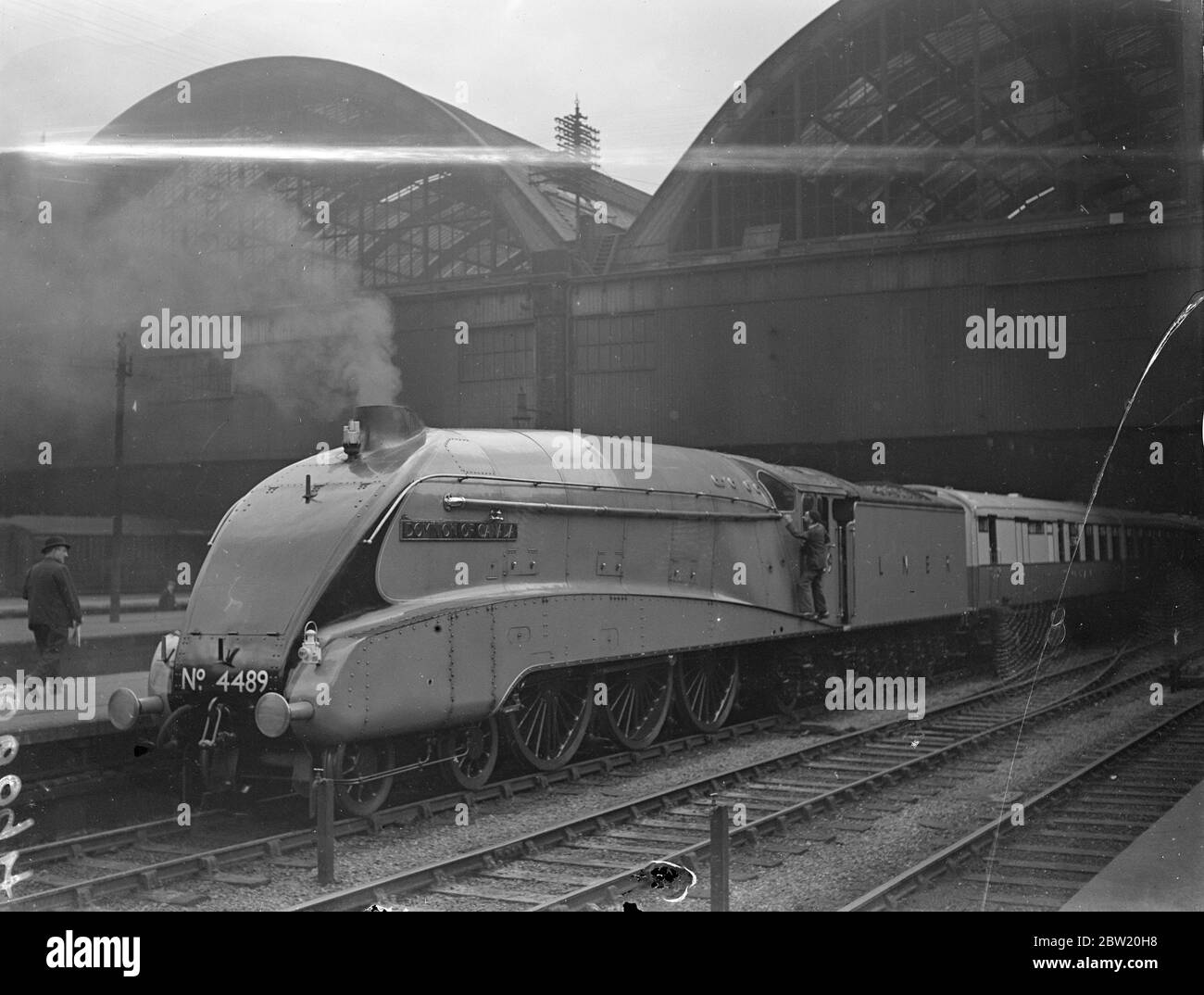 With a schedule under 4 hours for the 210 miles journey, the London and North Eastern Railway's new Coronation streamlined train speeding north to Grantham on a trial run. The locomotive drawing the express is Dominion of Canada, one of the fastest in the British Empire. The train at King's Cross station. 30 June 1937 Stock Photo