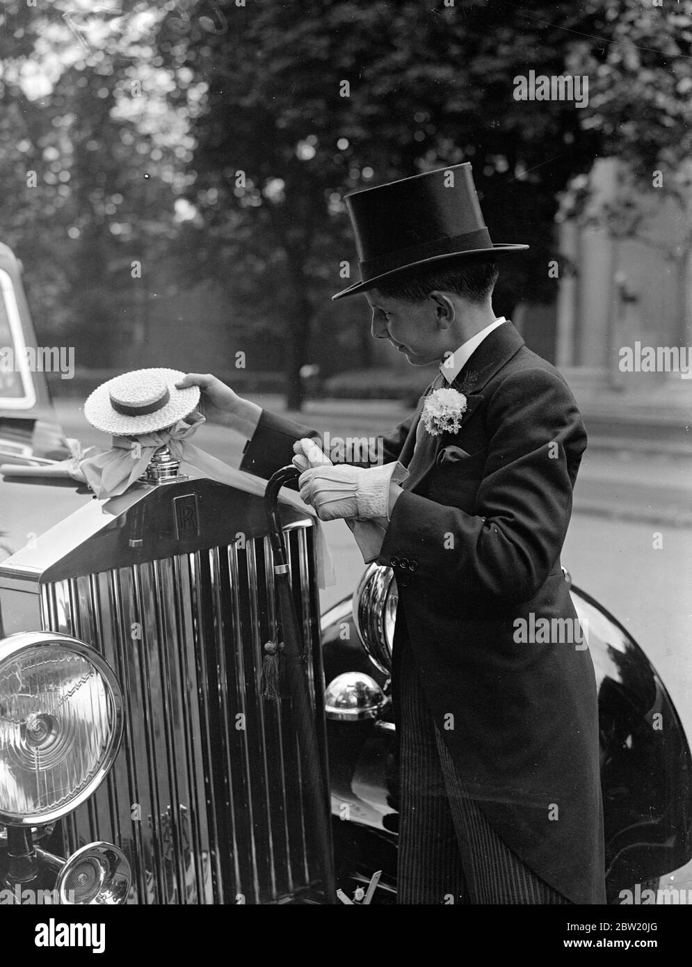 Bryan Adams, a Harrow boy with a Harrow hat car mascot at Lord's where the Eton - Harrow cricket match had started. Harrow are attempting to score the first cricket win since 1908 over their great rivals, Eton, in the annual two-day match. 9 July 1937 Stock Photo