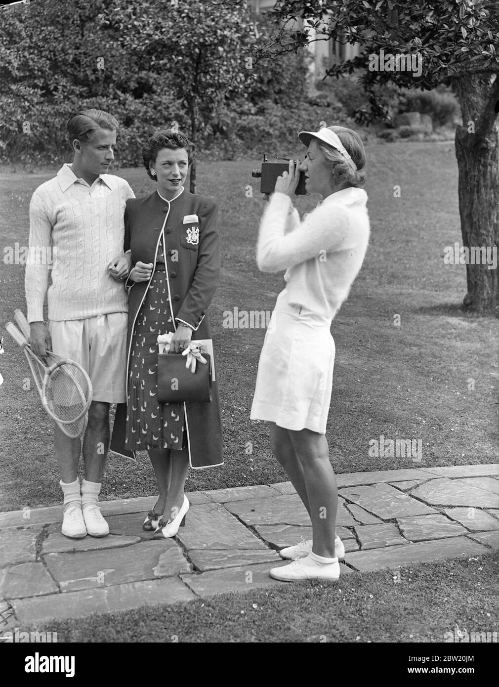 Filming Bunny Austin and his wife, at after Wimbledon tennis party. Prince Arthur of Connaught and many famous tennis players were present at the lawn tennis exhibition matches and American tournament held at 41, West Hill, Highgate, lent by Sir Arthur and Lady Crosfield. Photo shows,H W (Bunny), Austin and his wife, Phyllis Konstam, the actress being filmed by Miss Hersey Brookes, daughter of Norman Brookes, the famous tennis player. 5 July 1937 Stock Photo