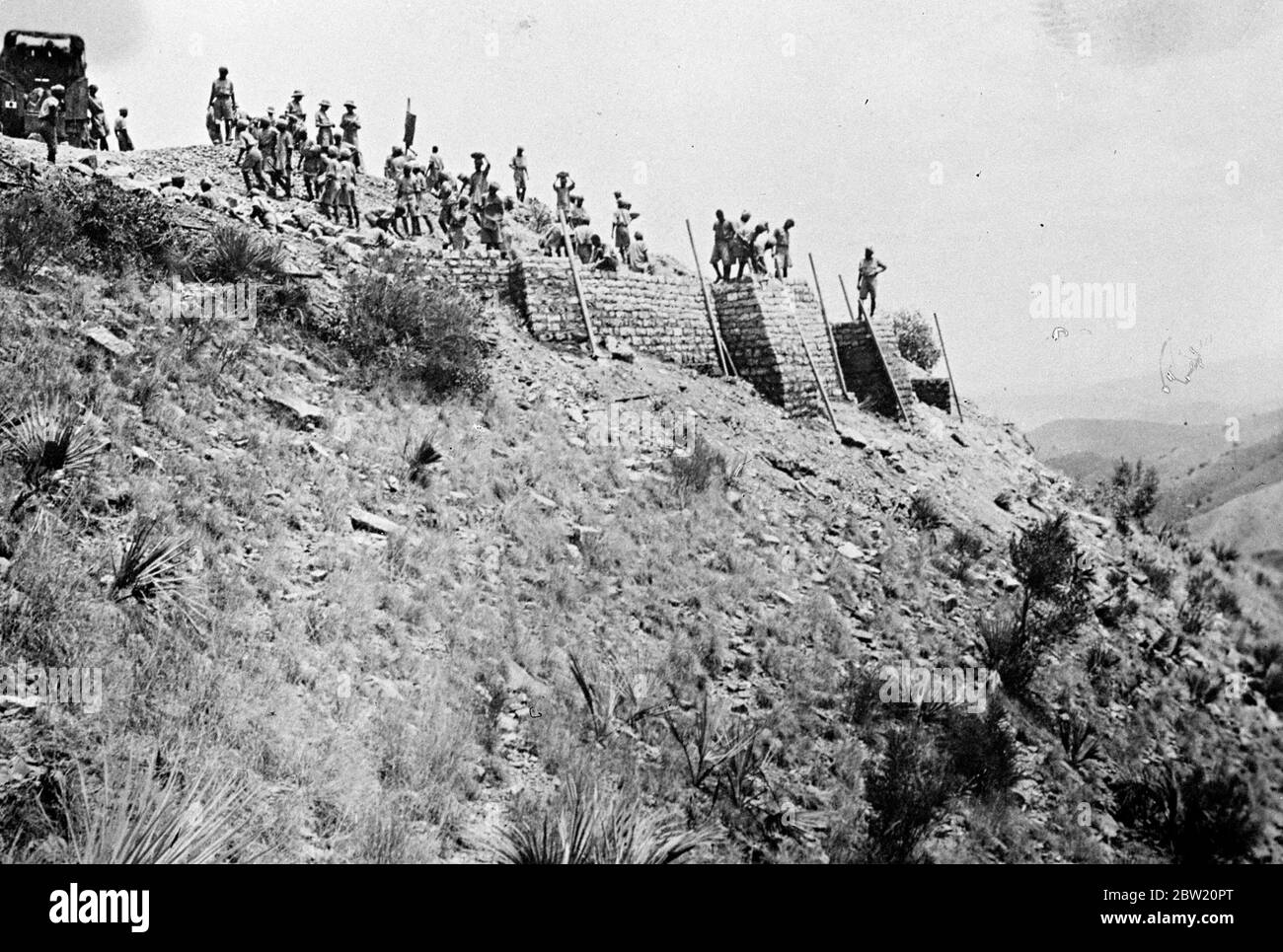 British forces are now consolidating their position on the North West Frontier of India [now in Pakistan], where they had been waging a big scale campaign against rebellious tribesmen stired up by the elusive Fakir of Ipi. British Indian troops building a fortress was an imminence near the Iblanke Spur. 19 July 1937 Stock Photo