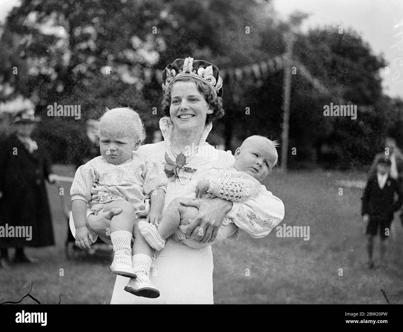 The Queen had her hands full. Dartford's smiling Carnival Queen, Miss Barbara G Fox, holding Deirdre Ann Holden (right) and David Allan Collins, two of the entries in the baby show, held in connection with the hospital Carnival. 24 June 1937 Stock Photo