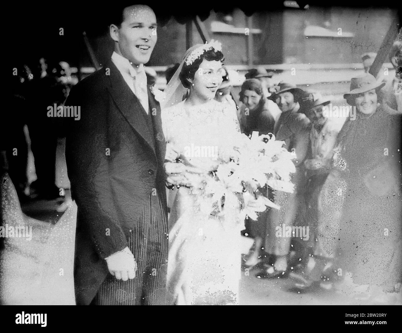 The bride and groom leaving the cathedral after the ceremony. Miss Elizabeth Coates, daughter of Sir Clive and Lady Celia Coates, was married to Mr William Harris at Southwark Cathedral. The Archbishop of York and the master of the temple assisted at the ceremony. 15 July 1937. Stock Photo