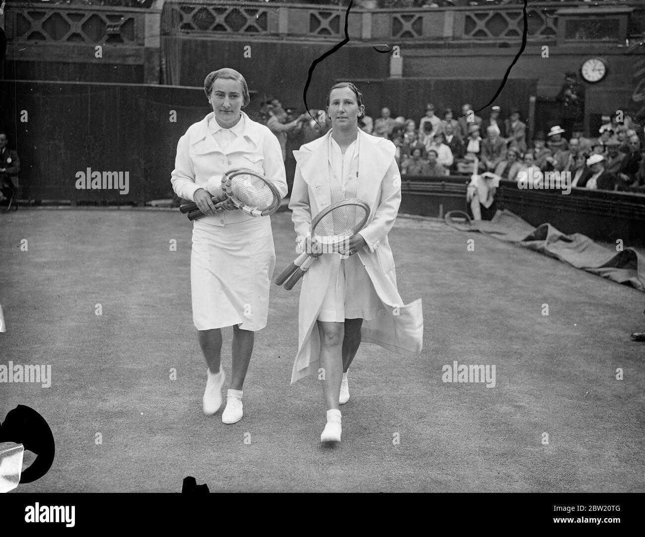 Miss Dorothy Round of Great Britain and Mme R. Mathieu, walking on to the Centre Court for the semi-final of the women's singles at Wimbledon. Miss Dorothy Round won by 6 - 3, 6 - 0 and she will now meet Mme J. Jedrzejowska of Polland in the final. 1 July 1937 Stock Photo