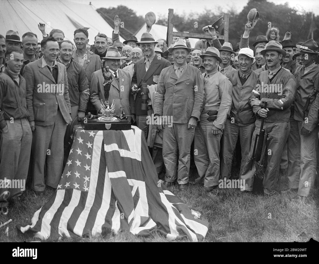 Great Britain retains the Pershing Cup by defeating the American small-bore rifle team at Bisley, Surrey. The match was the first that has taken place since general Pershing presented the Cup in 1931 when Britain won the trophy. The English (left) and American teams with the Pershing Trophy. 10 July 1937 Stock Photo