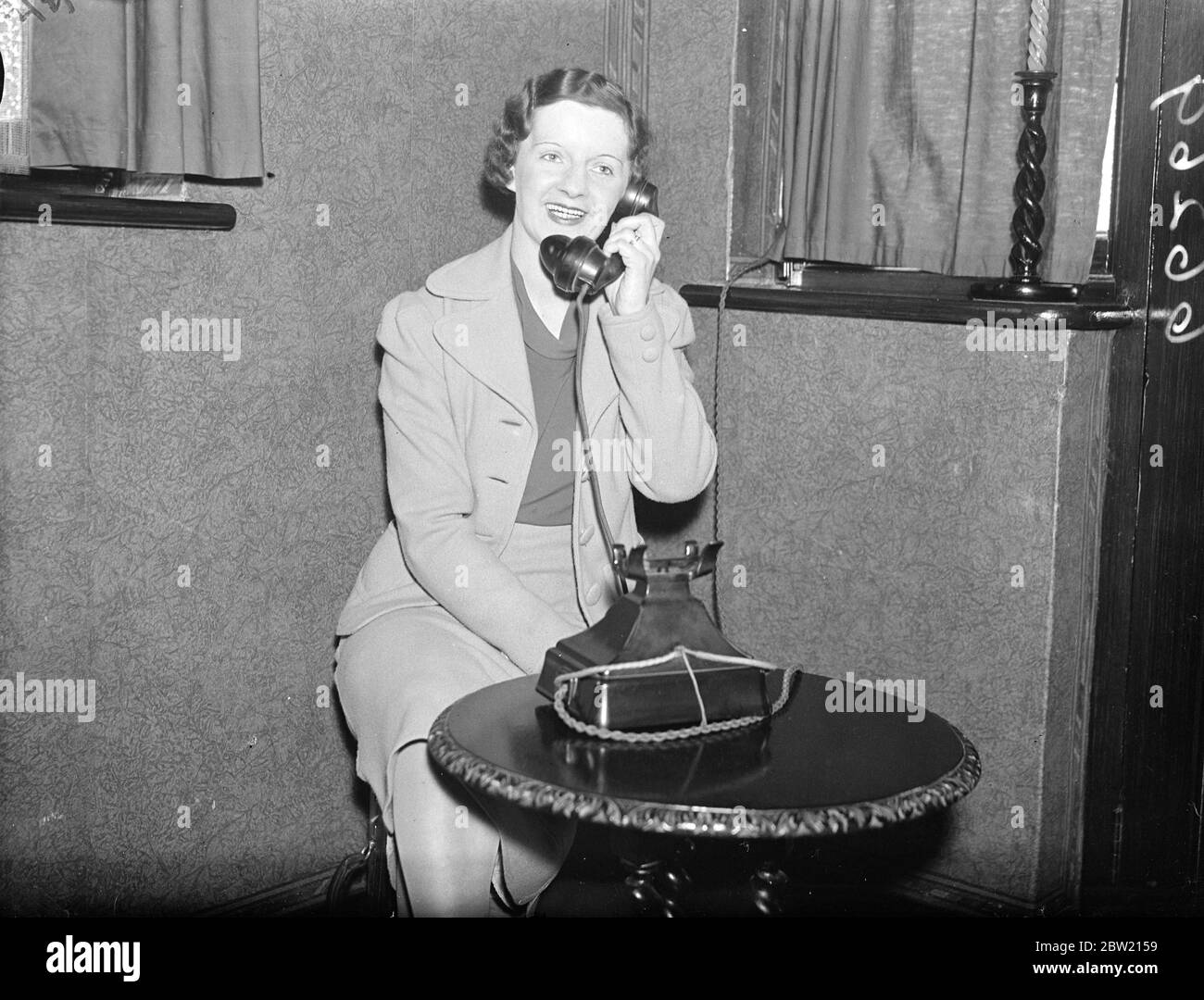 Mrs A S Wilcockson speaking to her husband from her home in Croydon. To congratulate the first successful transatlantic British air man Captian A.S Wilcockson and Mr T.A Valette, radio operator, their wives who spoke to them by telephone from home. Both women had kept an all-night vigil beside the telephone and followed the progress of the flying boat across the Atlantic until it landed. 6 July 1937 Stock Photo