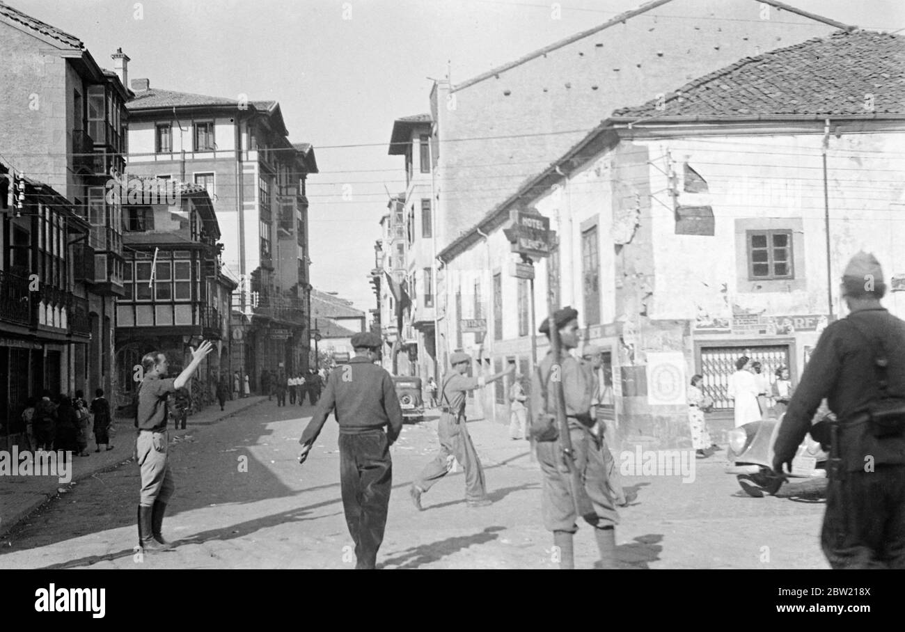 Rebel soldiers in their shelves scarred Street of Rainosa. Spanish rebel forces advancing rapidly on Santander Northern Spain, captured one of the most important manufacturing towns in the country and garment centre. The optic occupation was of the utmost strategical importance because it united to flanks of the affected imprisonment of members of villages where there are government troops. 19 August 1937 Stock Photo