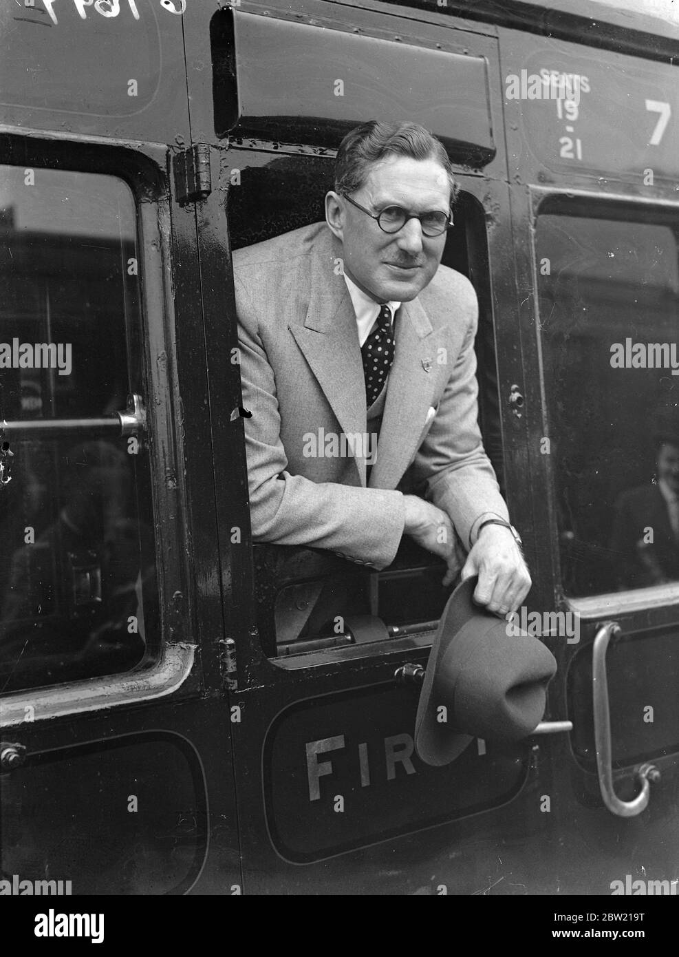 Captain Eyston in his carriage window, who is shortly to attempt to set a new world speed record of 400 miles an hour. They left Waterloo station with his wife and daughters, Madelyn and Betty on the Aquatania boat train for America. 25 August 1937 Stock Photo