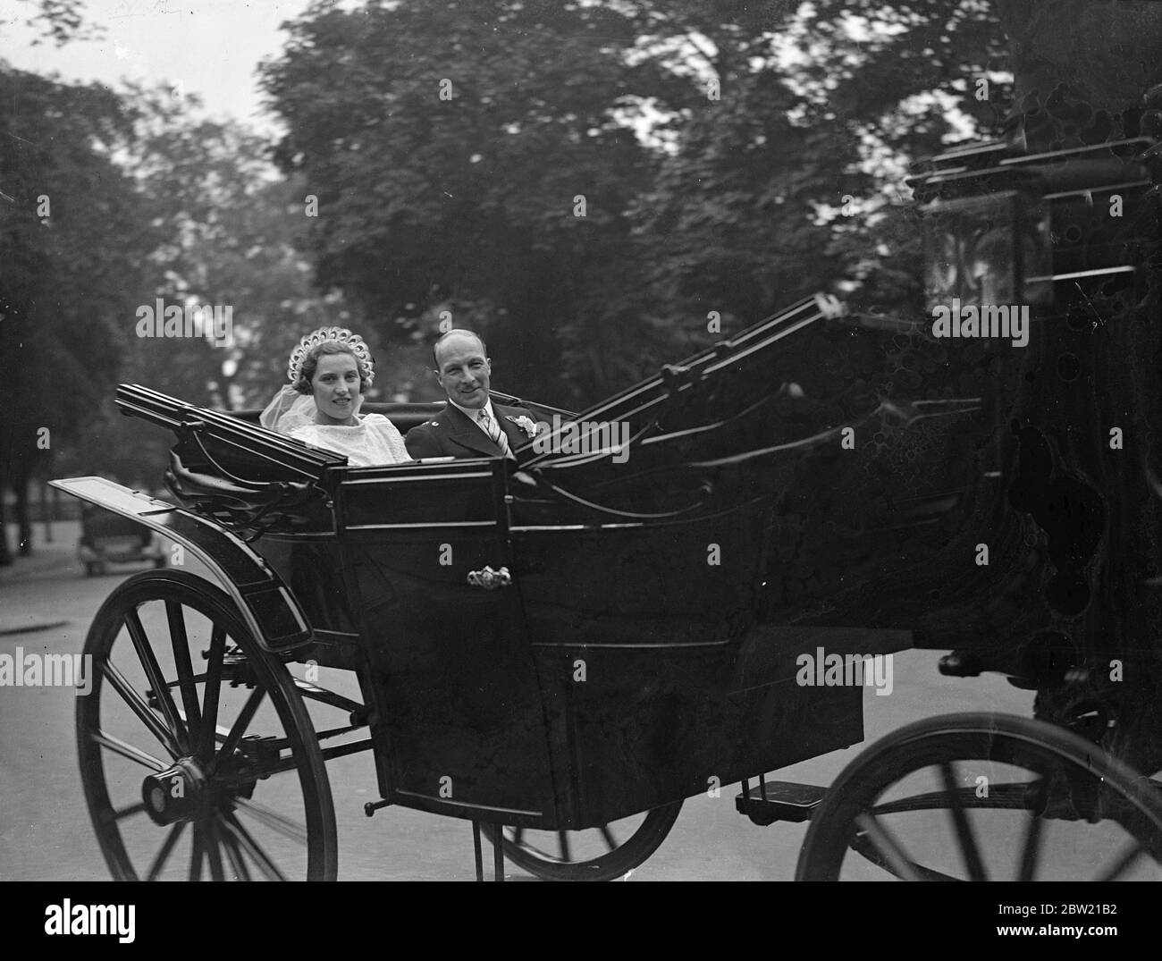 Four of the grey horses and the coach which the Duke of Windsor sold when he left England, and which were stabled at the Royal Mews when he was King, were used by Miss Helen Maud Edith Layfield, and Mr George Humble of Northumberland when they were married at Dulwich Chapel. The horses wore the harnesses which the Duke sold with them. The couple riding in the coach after the wedding. 28 August 1937 Stock Photo