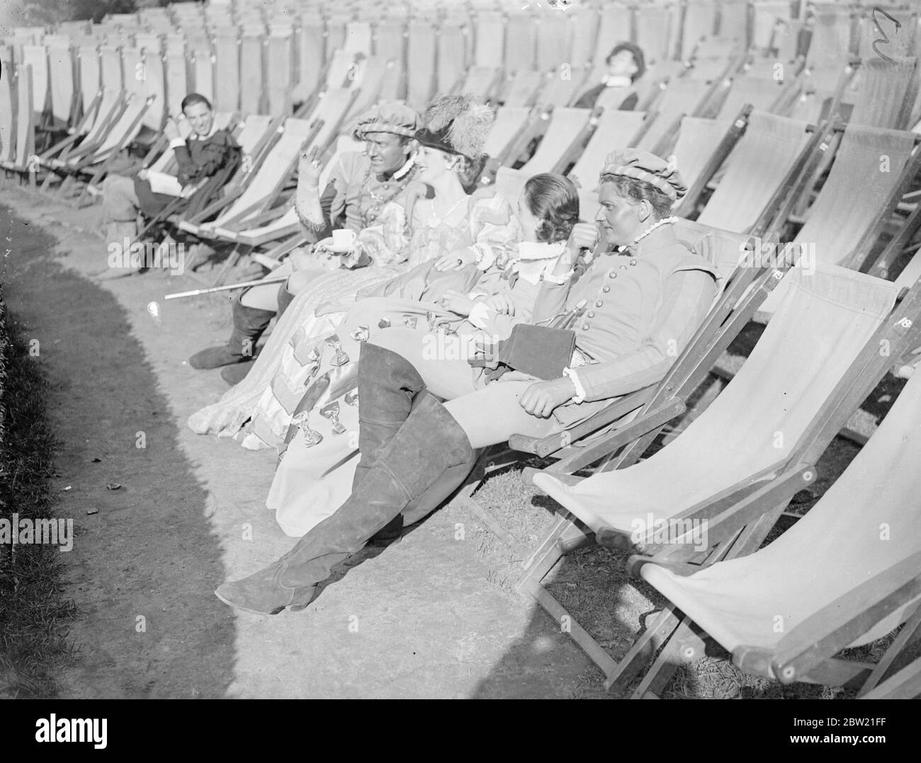 For the principals in all-time costume, reclining in modern deckchairs as they watch a rehearsal of a comedy of errors at the open-air theatre in Regent's Park. They are (nearest): Robert Eddison, who plays one of the twins in the play, Janet Johnson, Molly Johnson and Peter Murray Hill, the second twin. 3 September 1937 Stock Photo