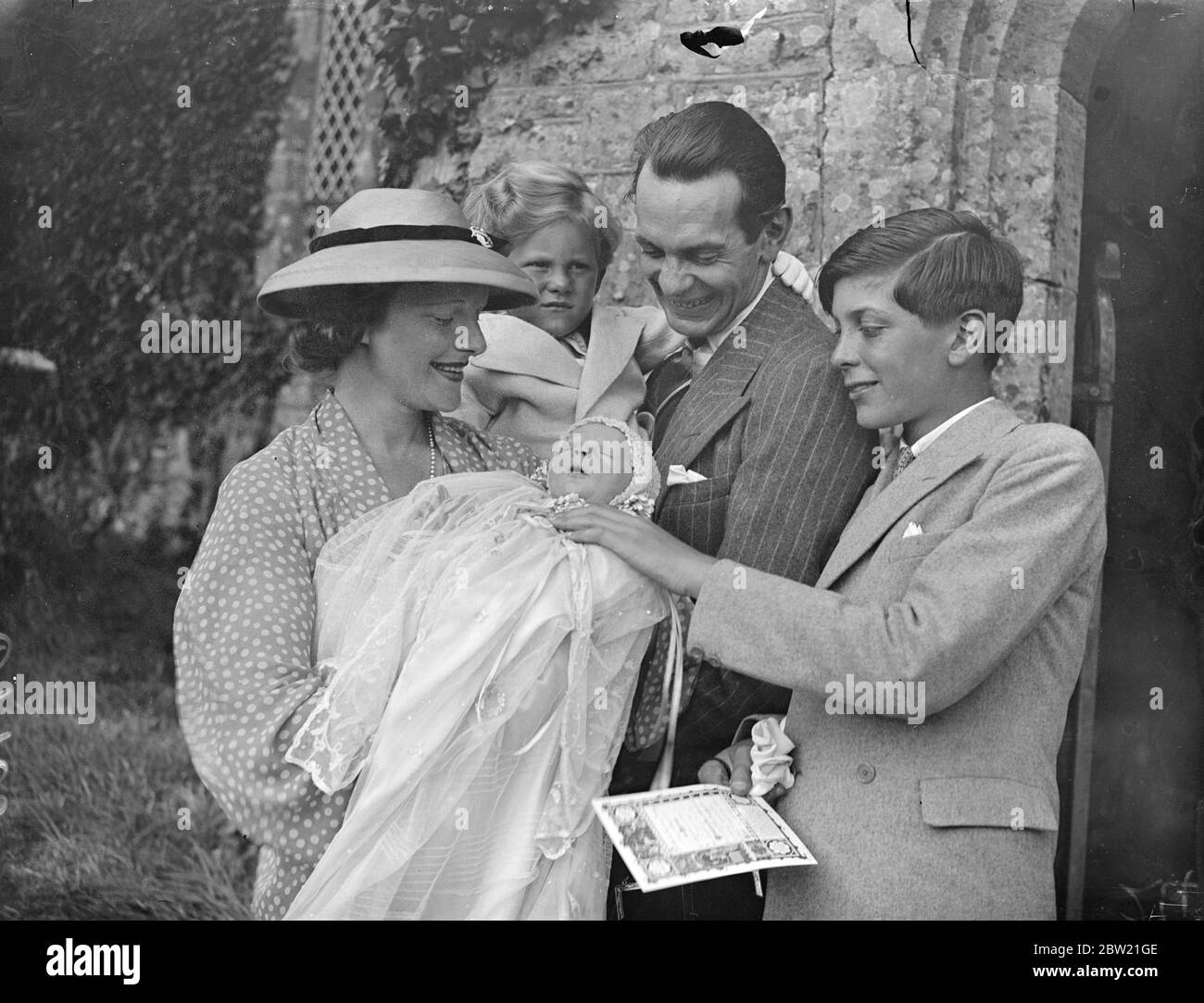 The actor Raymond Massey and his wife Adrienne Allen, with the baby, Anna and their two sons Daniel and Geoffrey (right) after the christening at Thakeham, Sussex. 3 September 1937 Stock Photo