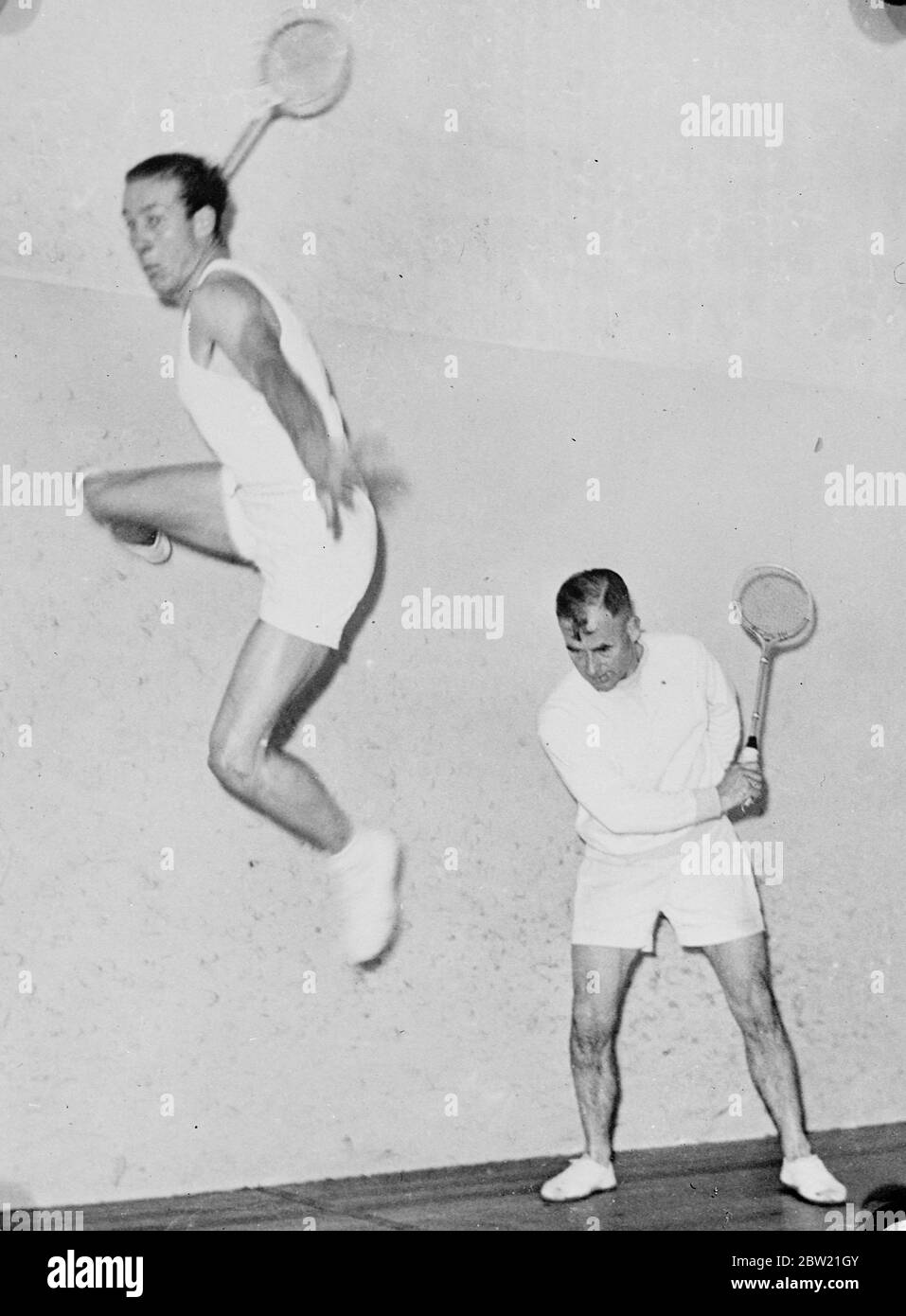 S. M. Kimpton, well-known Australian squash player, emulated the flyby running up a sidewall to make a shot during a match in Melbourne. The other player is P. W. Peers 30 August 1937 Stock Photo