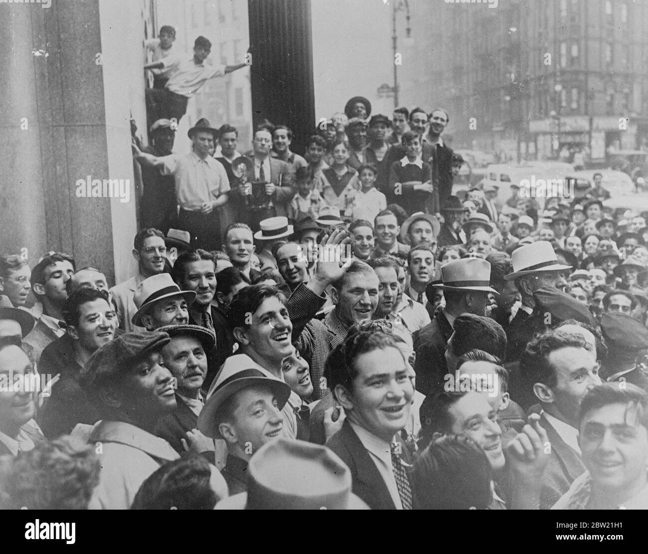 Tommy Farr, the British Empire champion made a gallant but unsuccessful attempt to wrest the world title from Joe Louis, surrounded by crowds outside the State building in New York before the big fight. Far went the whole distance with Louis but lost on points. 1 September 1937 Stock Photo
