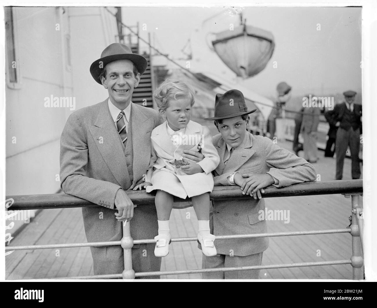 Raymond Massey, the film actor whose sudden collapse in Hollywood studio prevented him being present at the birth of his daughter, arrived at Southampto on the Queen Mary from America. Raymond Massey with his sons, Daniel (3) and Jeffrey (12) met him on arrival. 30 August 1937 Stock Photo