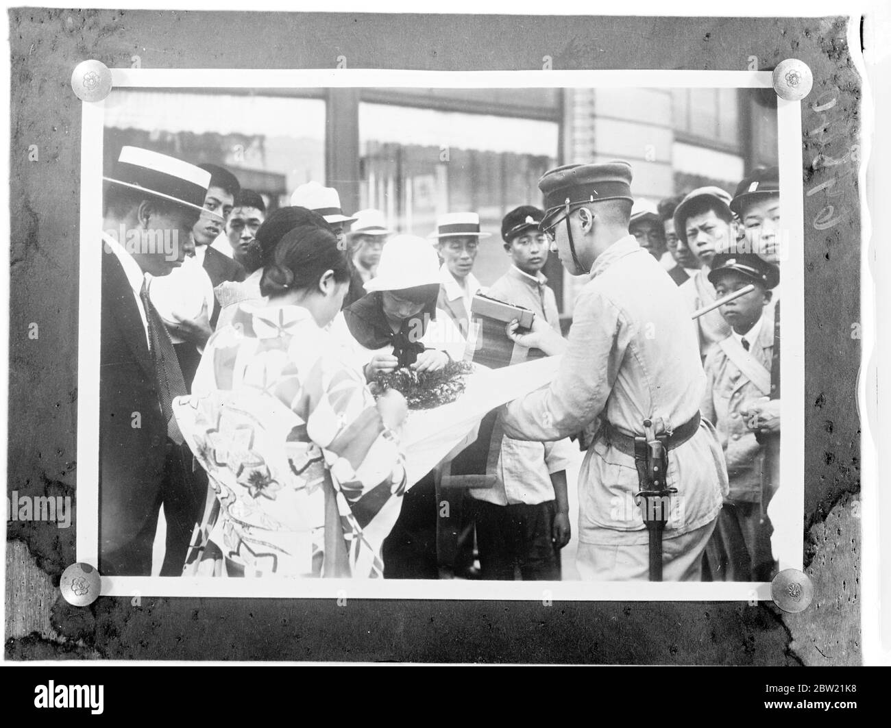 Japan's teeming millions are now firmly in the grip of war fever. A stream of money is pouring into the War Office in Tokyo as a result of street collections conducted by schoolchildren and every conceivable organisation. A young Japanese soldier selling stitches on a Japanese sun flag in a street of Tokyo, to raise funds for the war. [Second Sino - Japanese War] 30 August 1937 Stock Photo