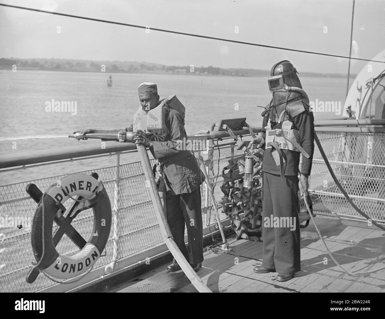 Commander Hughes, of the embarkation staff, made an official inspection of the crew and watch lifeboat in firefighting drills on the new troopship Dunera which leaves Southampton on her maiden voyage tomorrow with troops for China. 6 September 1937. Stock Photo