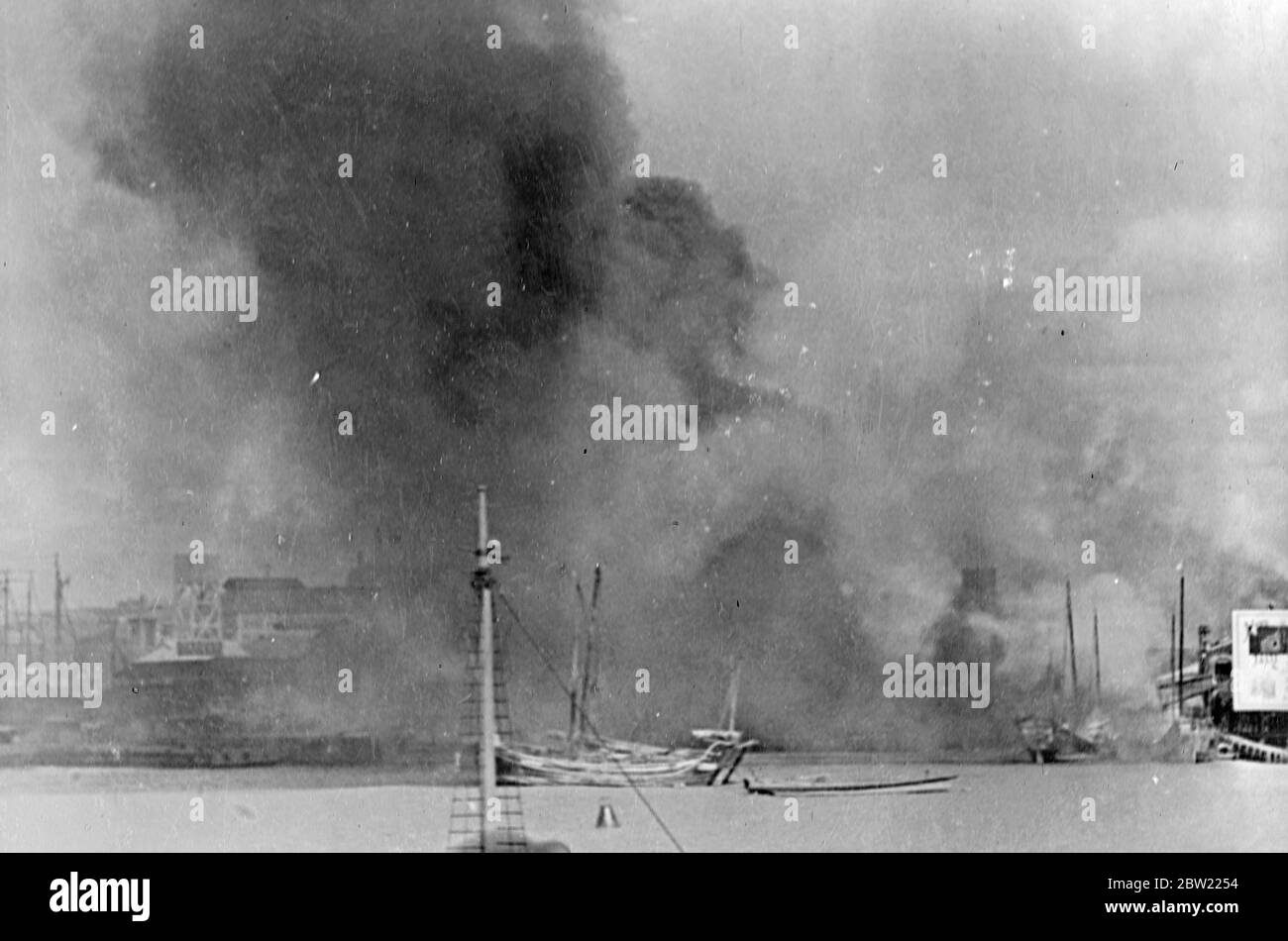 The clouds of black smoke rising from the big fires started in, Pootung, Shanghai [Pudong] by Japanese bombardments. Pootung lies on the bank of the Whangpoo River [Huangpu River] opposite to the main city in the Chinese positions there had been relentlessly bombed by Japanese aircraft. 21 September 1937 Stock Photo